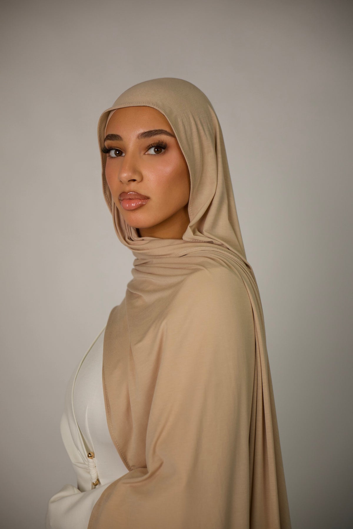 LOSYANA Breeze Jersey Hijab in goldenem Beige aus weichem Bambusstoff, getragen von einem Model im Profil
