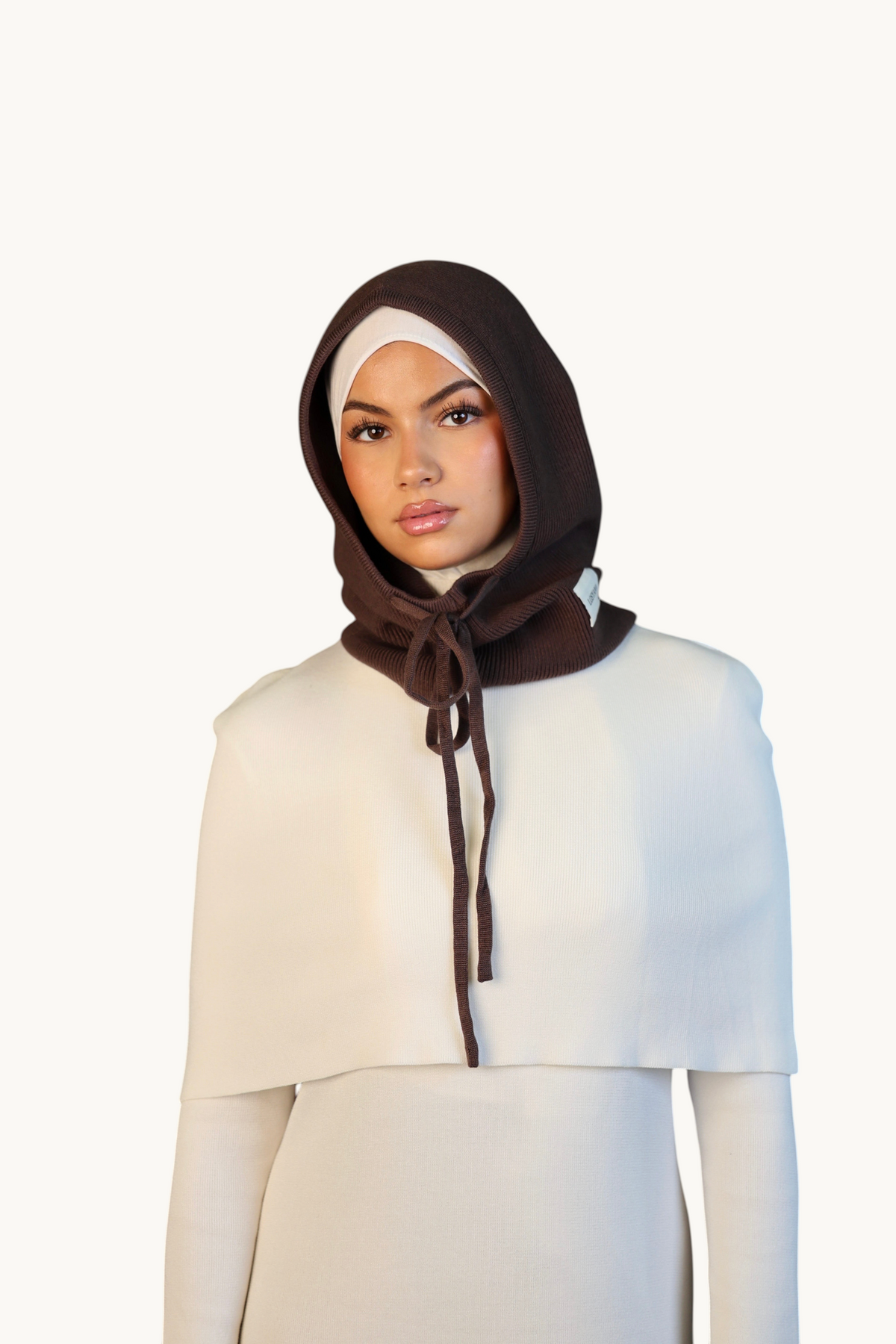 LOSYANA Balaclava in Espresso-Braun mit Kordelzug, getragen von einem Model über einem cremeweißen Oberteil