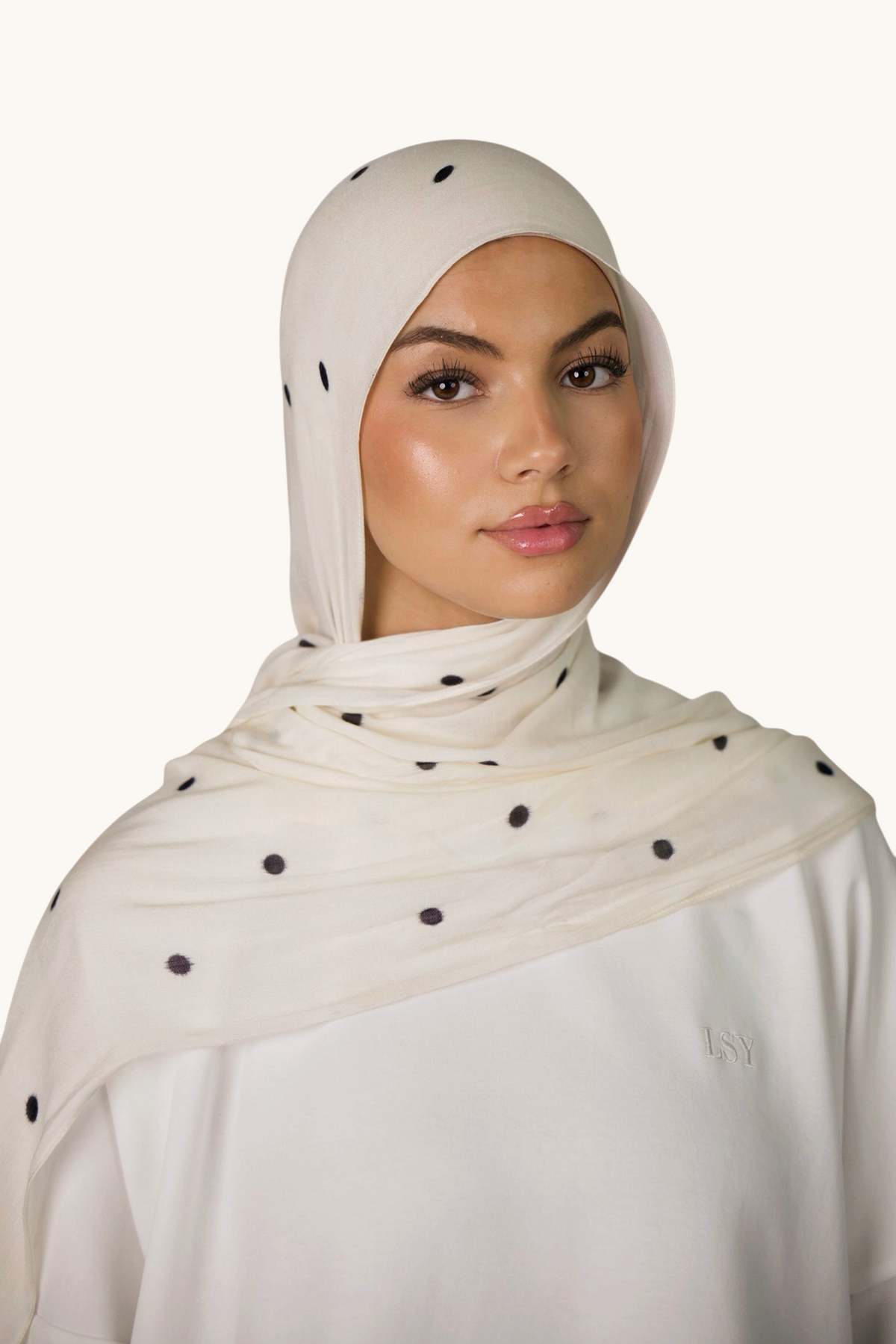 LOSYANA leichter Modal Hijab in Creme mit schwarzen Velour-Punkten, getragen von einem Model mit passender Bone.