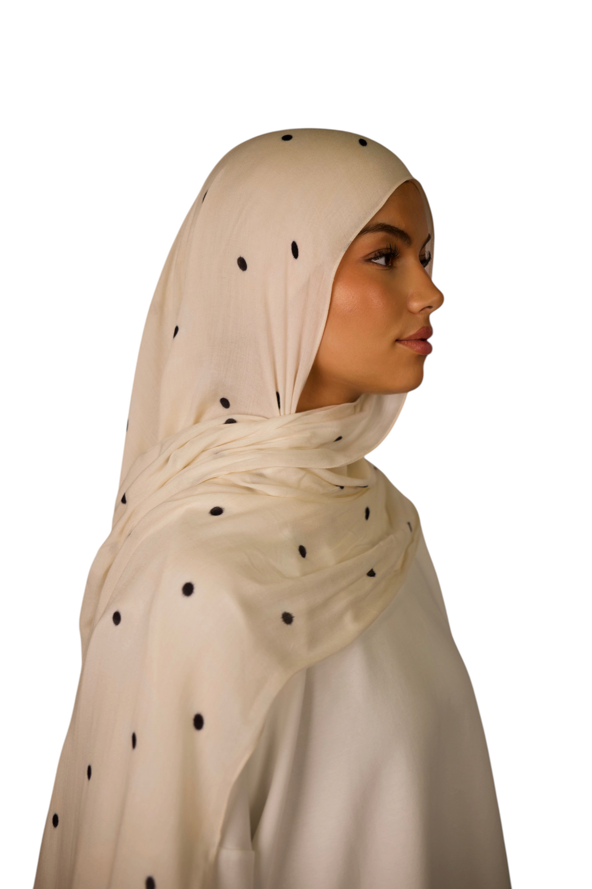 LOSYANA leichter Modal Hijab in Creme mit schwarzen Velour-Punkten, getragen von einem Model im Profil