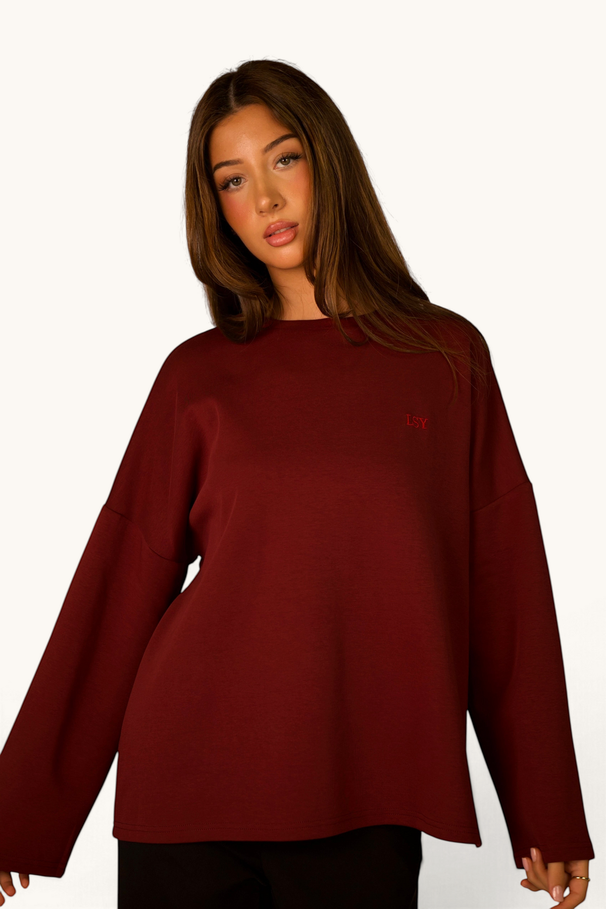 LOSYANA Langarmshirt in Bordeaux aus weicher Baumwolle mit LSY-Stickerei, getragen von einer jungen Frau
