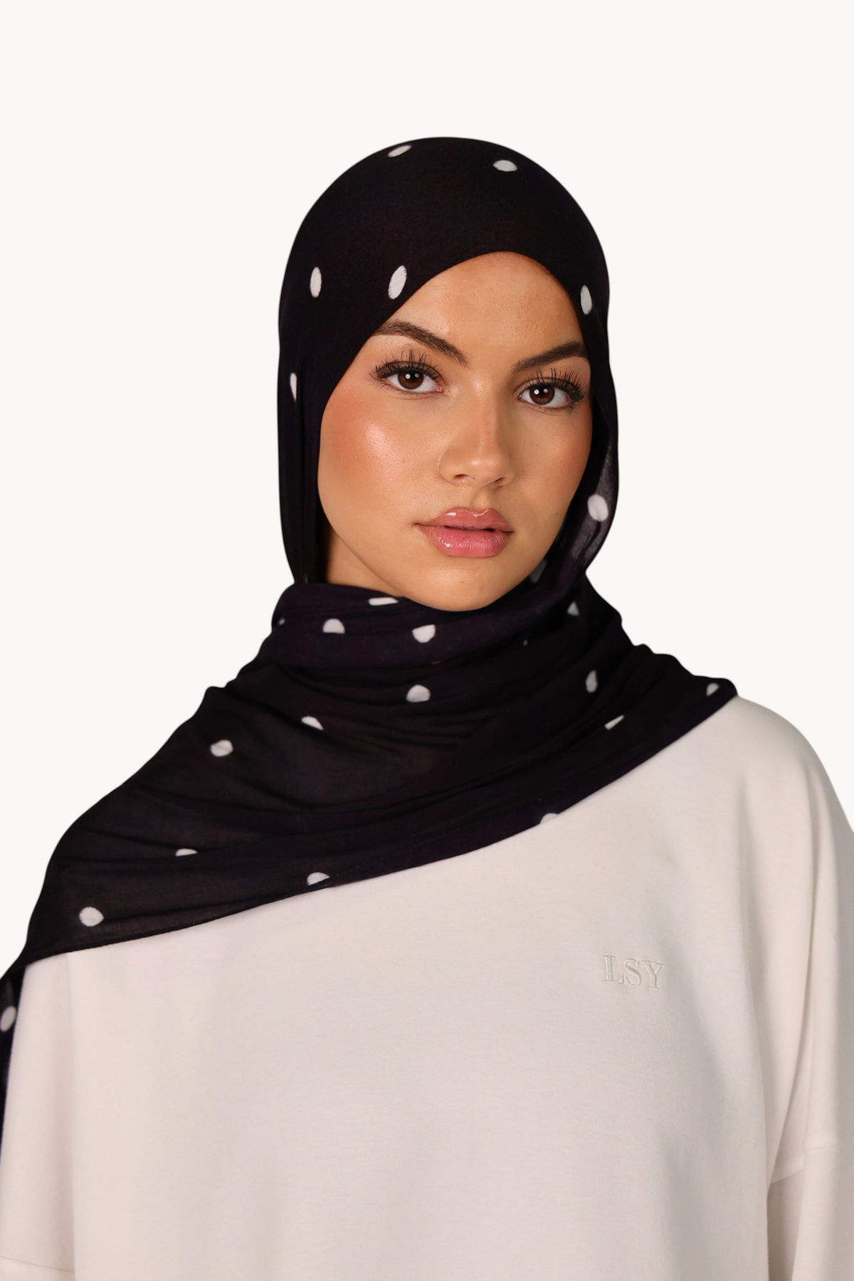 LOSYANA leichter schwarzer Modal-Hijab mit weißen Velour-Punkten, getragen von einem Model mit passender Bone.