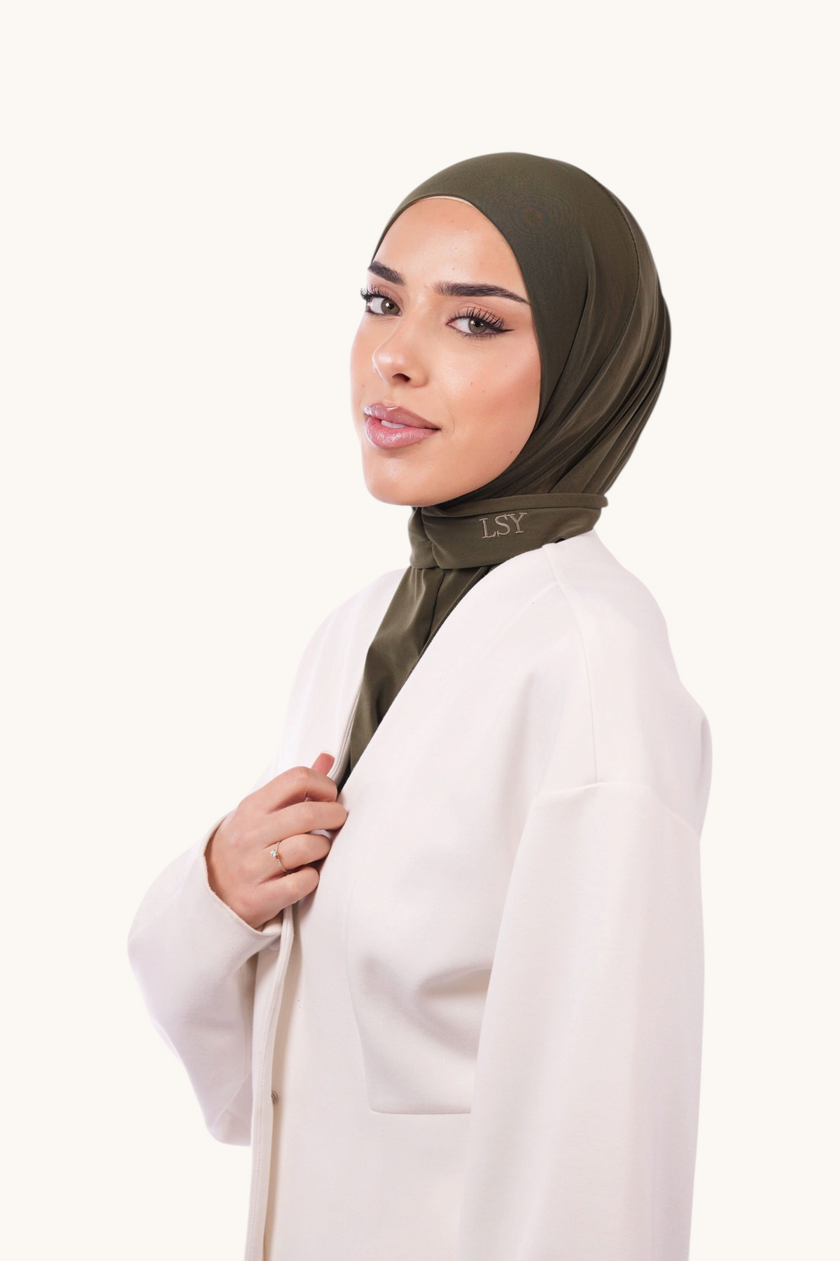 Hintergrundbild einer grünen Instant-Hijab von Losyana.Shop, bequem und stilvoll für muslimische Frauen, aus weichem Stoff.