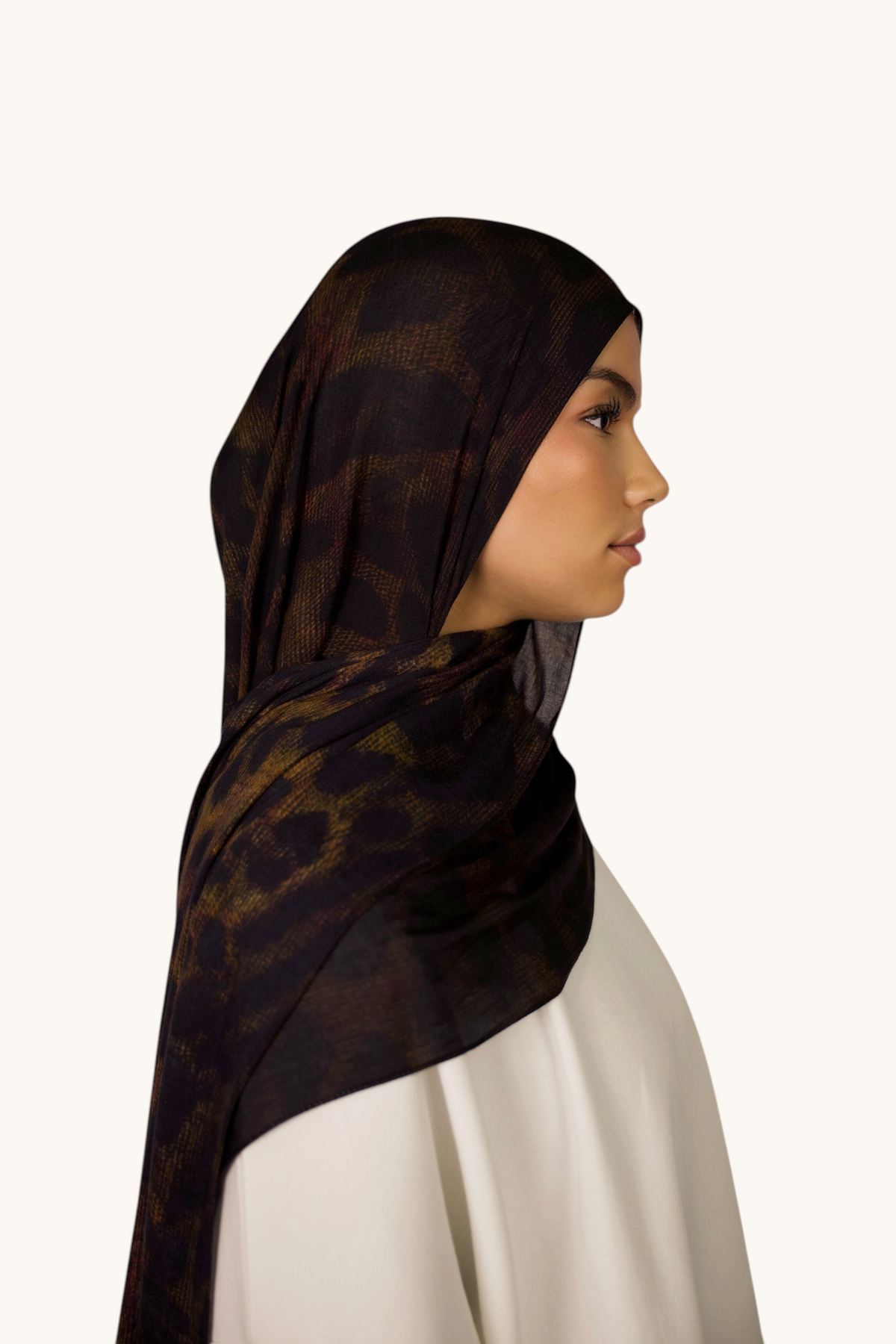 LOSYANA Hijab aus leichtem, transparentem Modal mit dunklem Leopardenmuster, getragen von einem Model im Profil