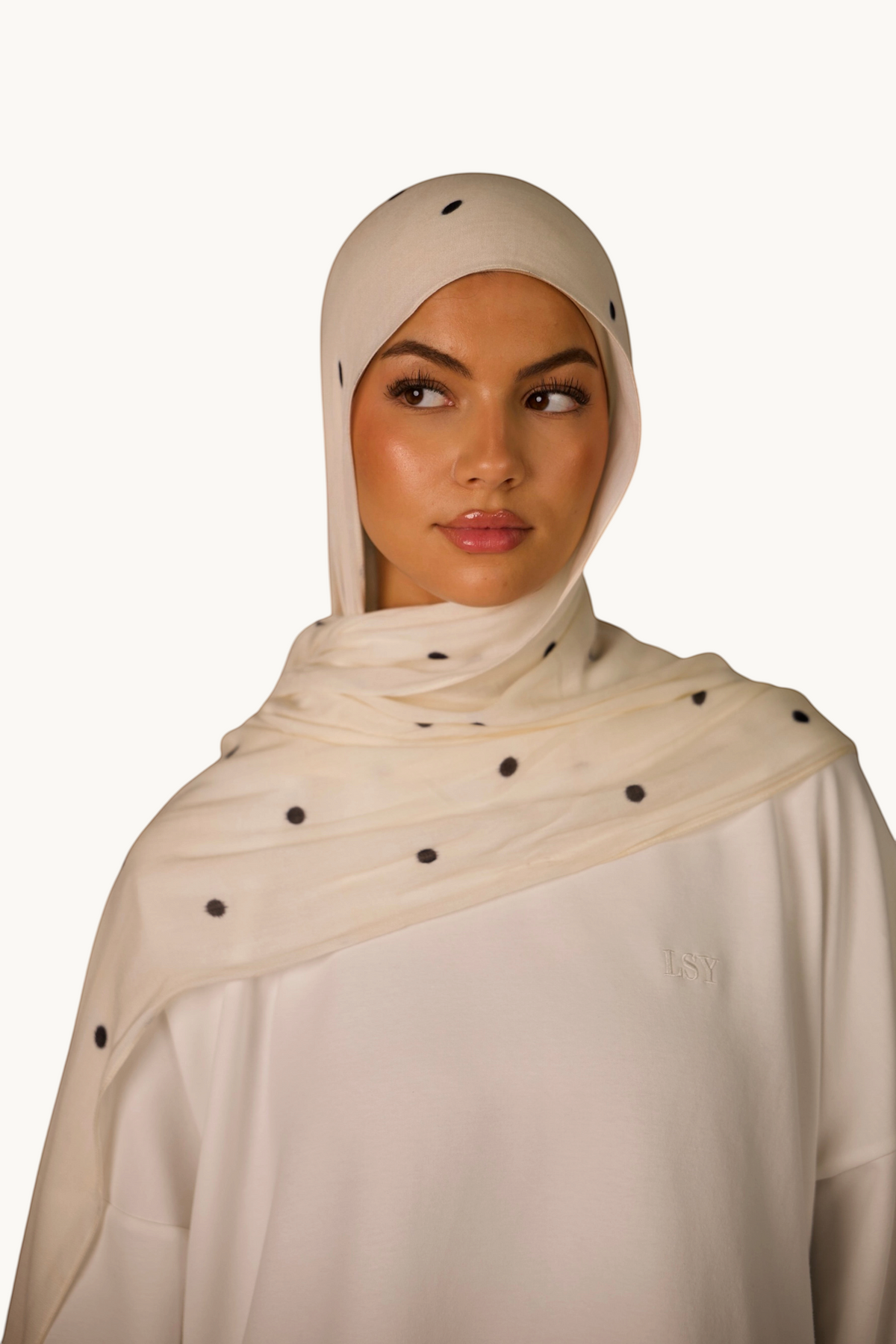 LOSYANA leichter Modal Hijab in Creme mit schwarzen Velour-Punkten, getragen von einem Model mit passender Bone.