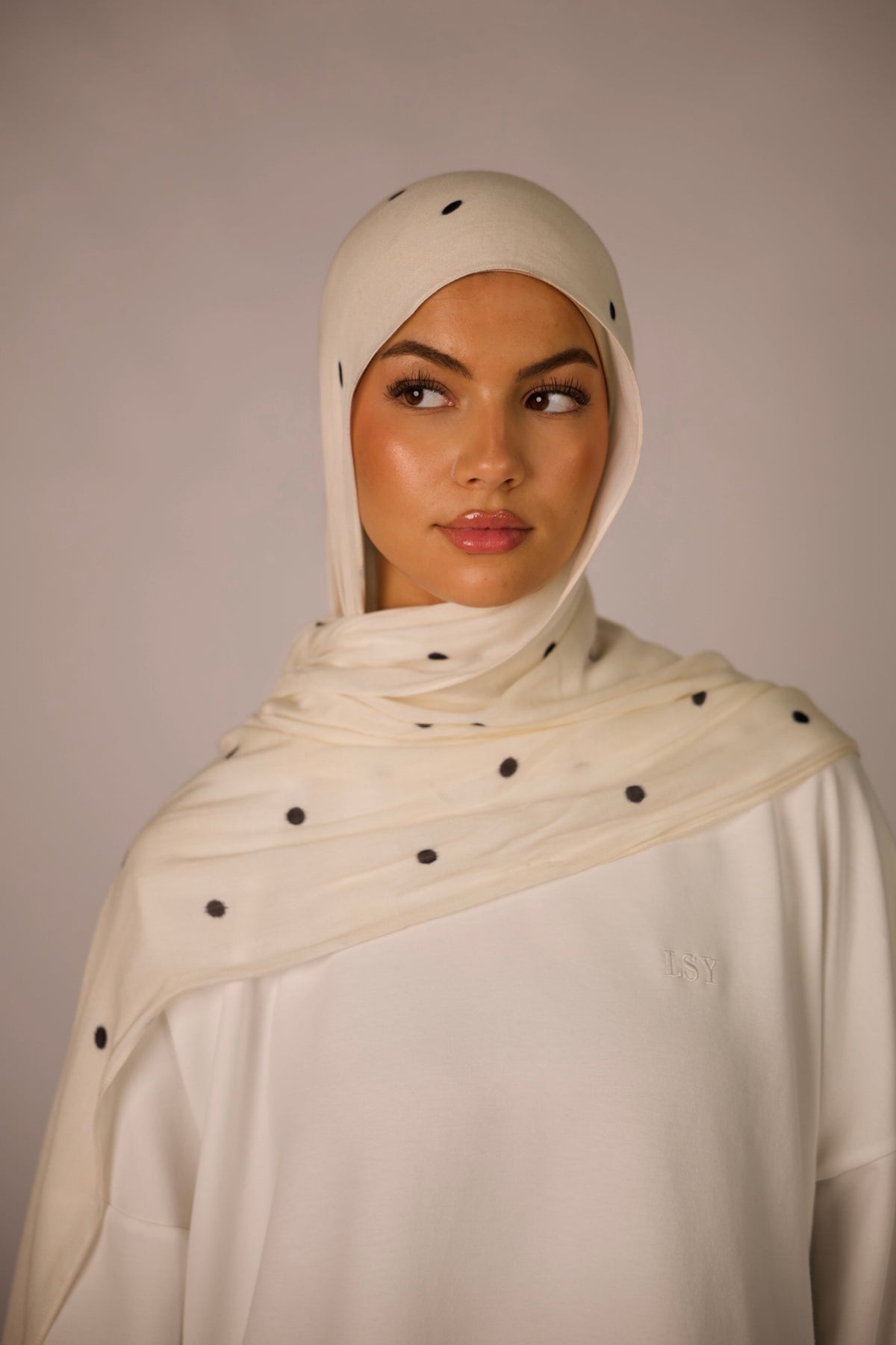 LOSYANA leichter Modal Hijab in Creme mit schwarzen Velour-Punkten, getragen von einem Model mit passender Bone.