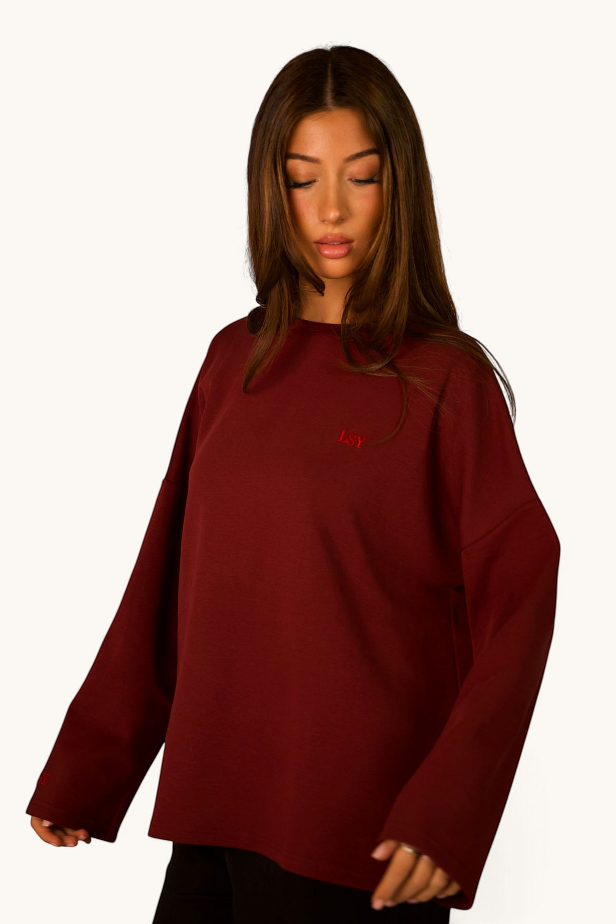 LOSYANA LSY Langarmshirt in Bordeaux aus weicher Baumwolle mit dezentem Logo-Stick an einer jungen Frau