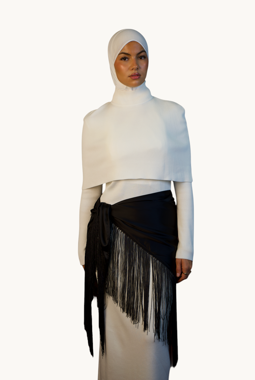 LOSYANA Fransen Cape in Schwarz aus weichem Satin mit langen Fransen, getragen von einem Model in weißem Outfit.