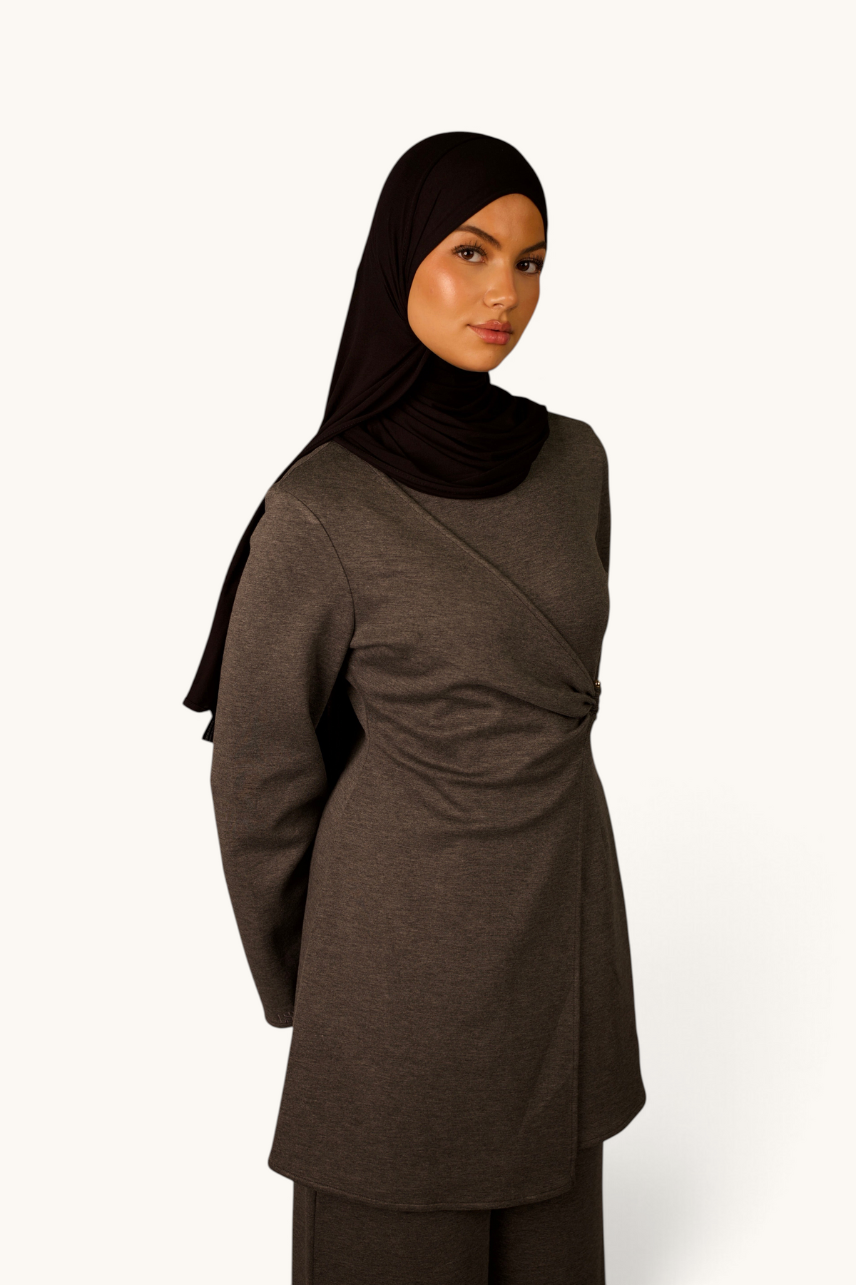 LOSYANA Valencia Zweiteiler in Grau mit tailliertem Oberteil, Raffung und Gold-Detail, getragen mit schwarzem Hijab