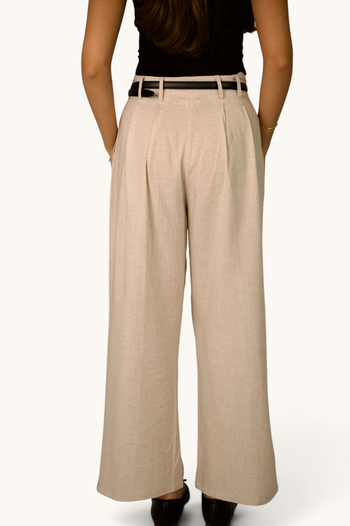LOSYANA Montmartre Leinenhose in Beige mit weitem Bein, Rückansicht an einem Model mit schwarzem Gürtel