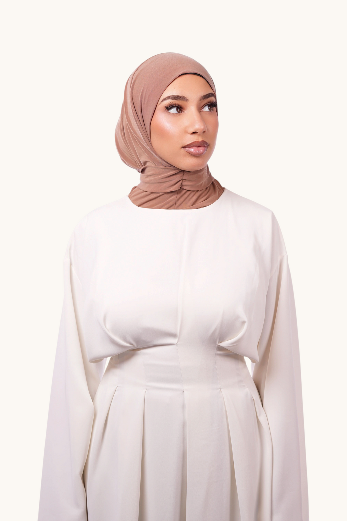Sandfarbener Instant-Hijab von Losyana.Shop, bequem und stilvoll, zeigt den gefalteten Hijab aus weichem Stoff.
