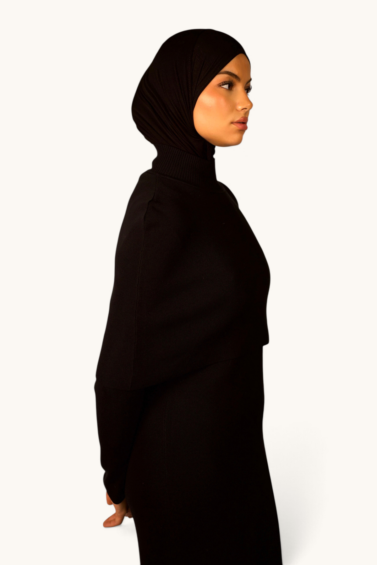 LOSYANA schwarzes Strickkleid mit Cape-Detail und Stehkragen an einem Model in Seitenansicht