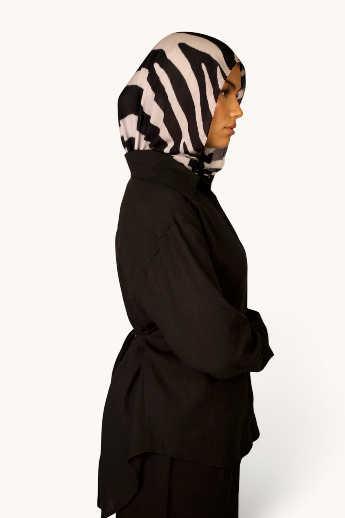 LOSYANA Premium Leinen Bluse in Schwarz mit Taillenband und Schulterpolstern, getragen von einem Model mit Zebra-Hijab