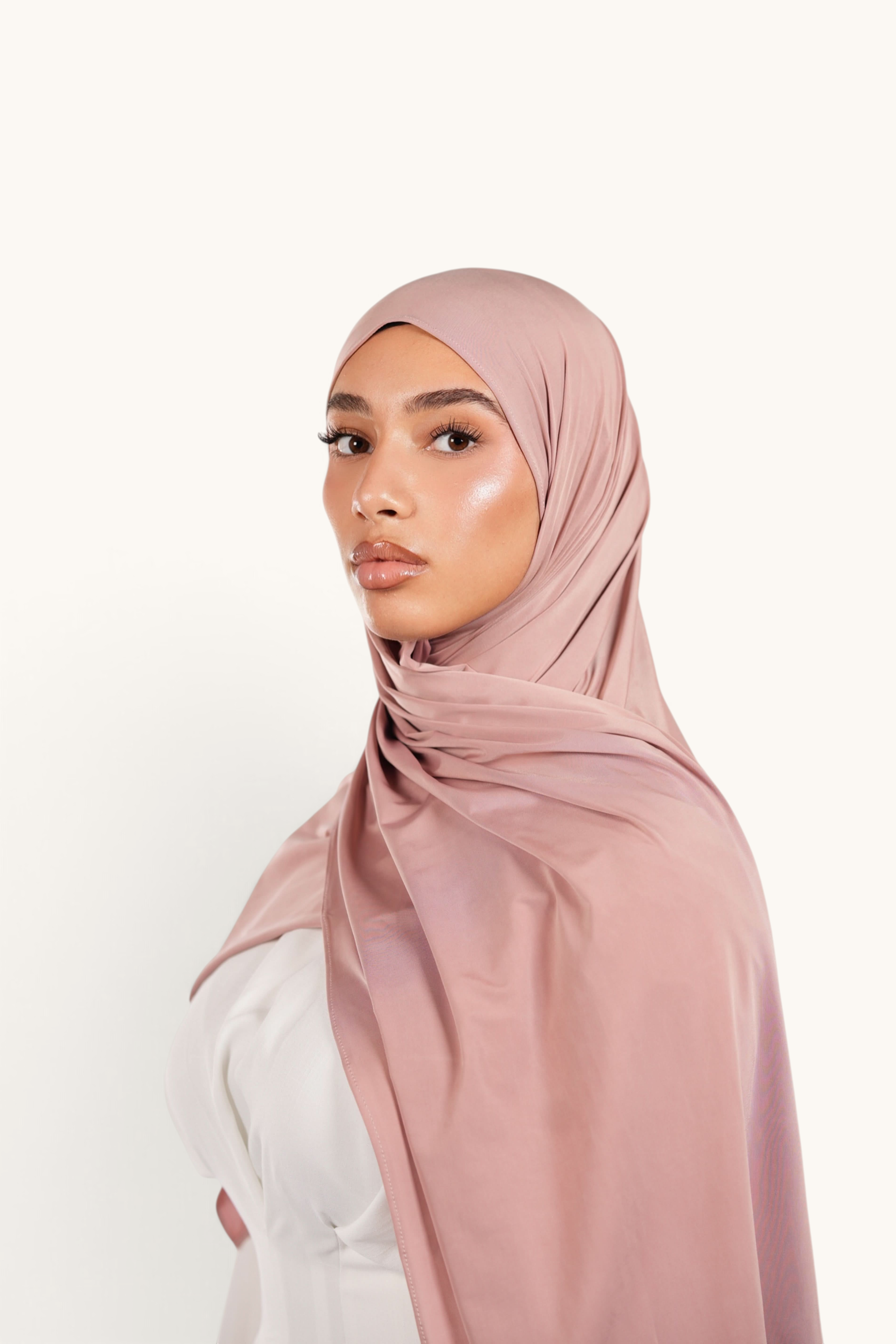 Model wearing a LOSYANA Liquid Jersey hijab in almond, featuring a lightweight, elegant, and soft satin-like finish.