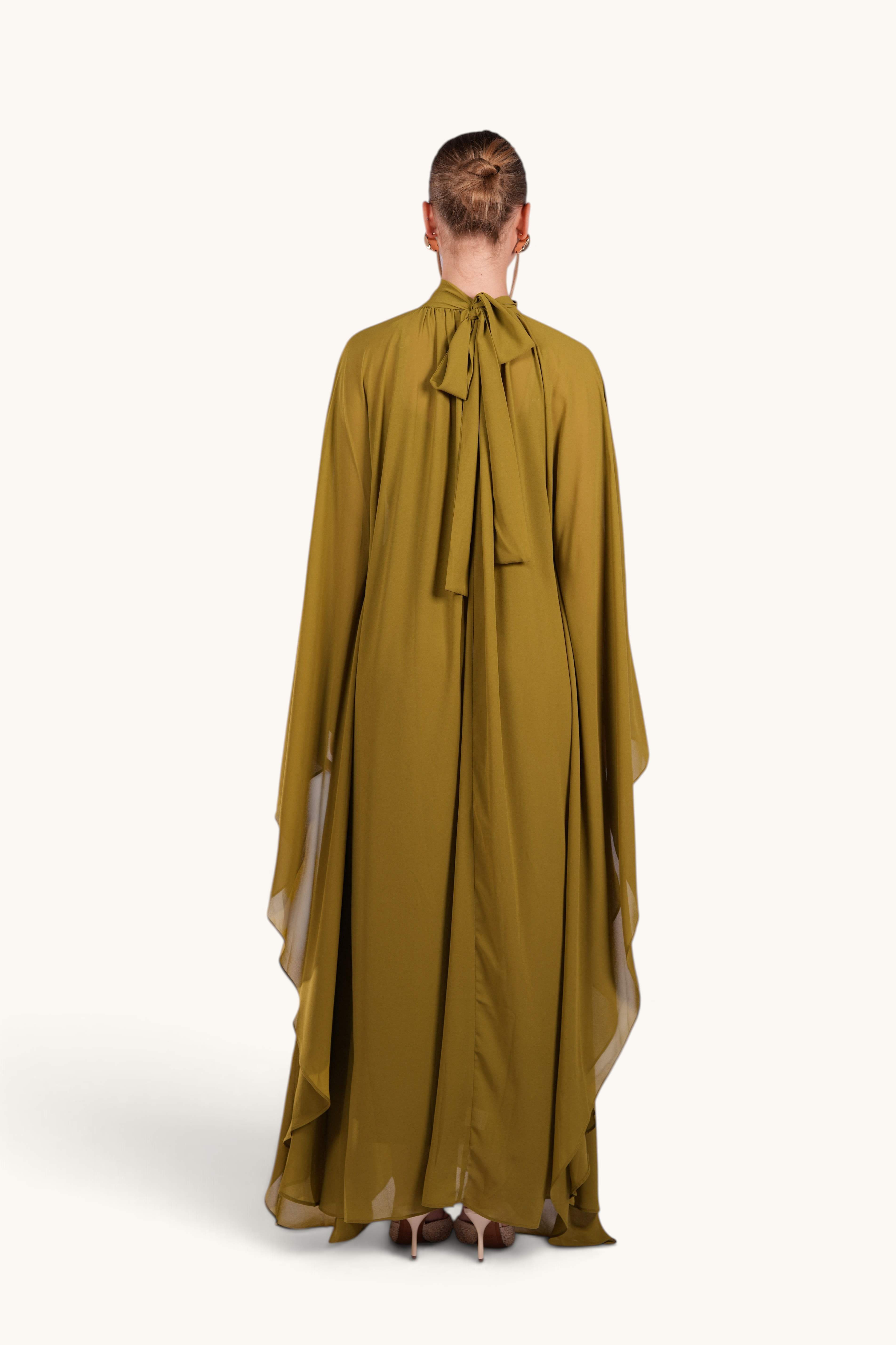 Back view of LOSYANA Andalusia lime green chiffon cape dress with a high neck tie detail on a model