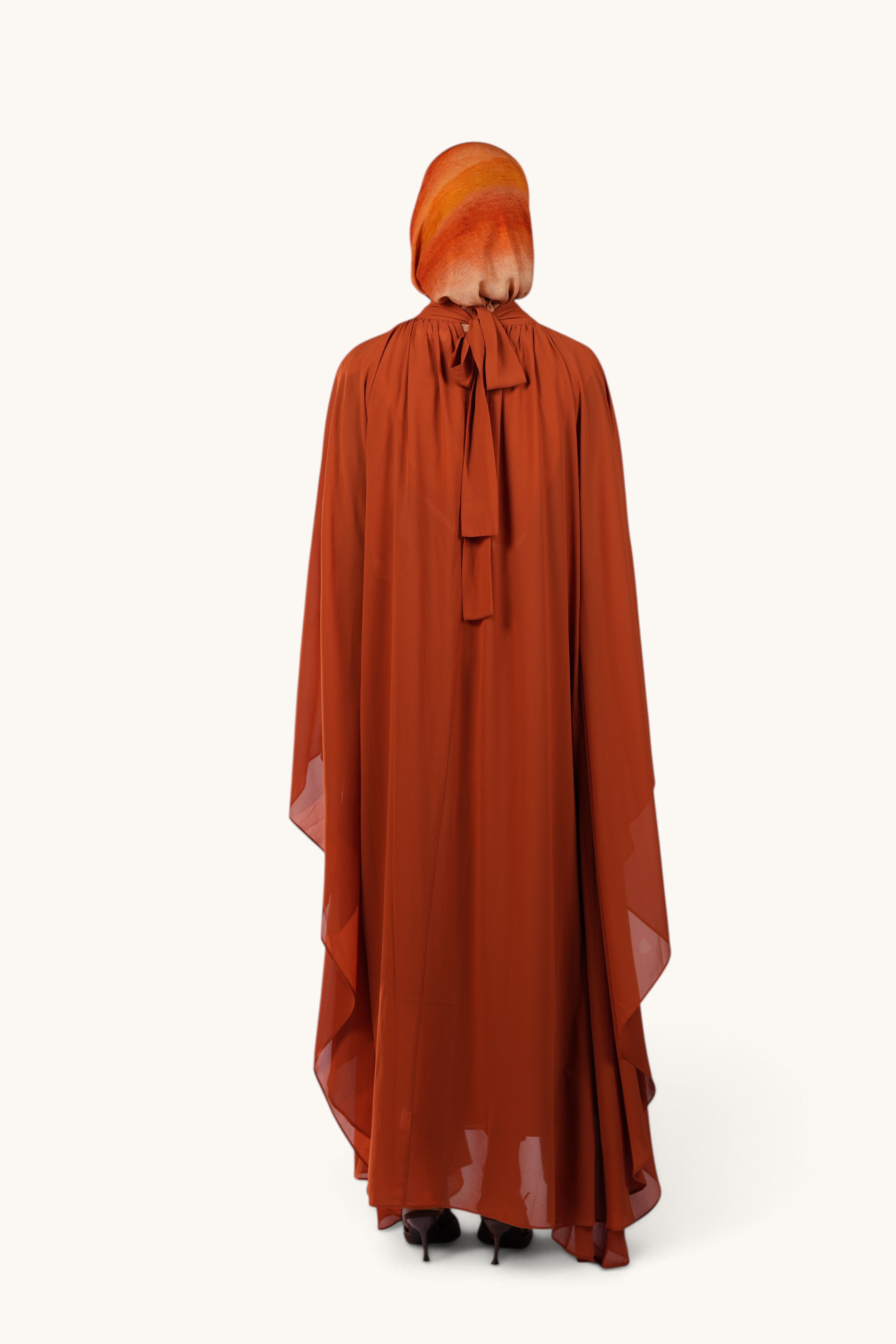 LOSYANA Andalusia sunset orange chiffon cape dress with a tie-neck detail worn by a model from the back view
