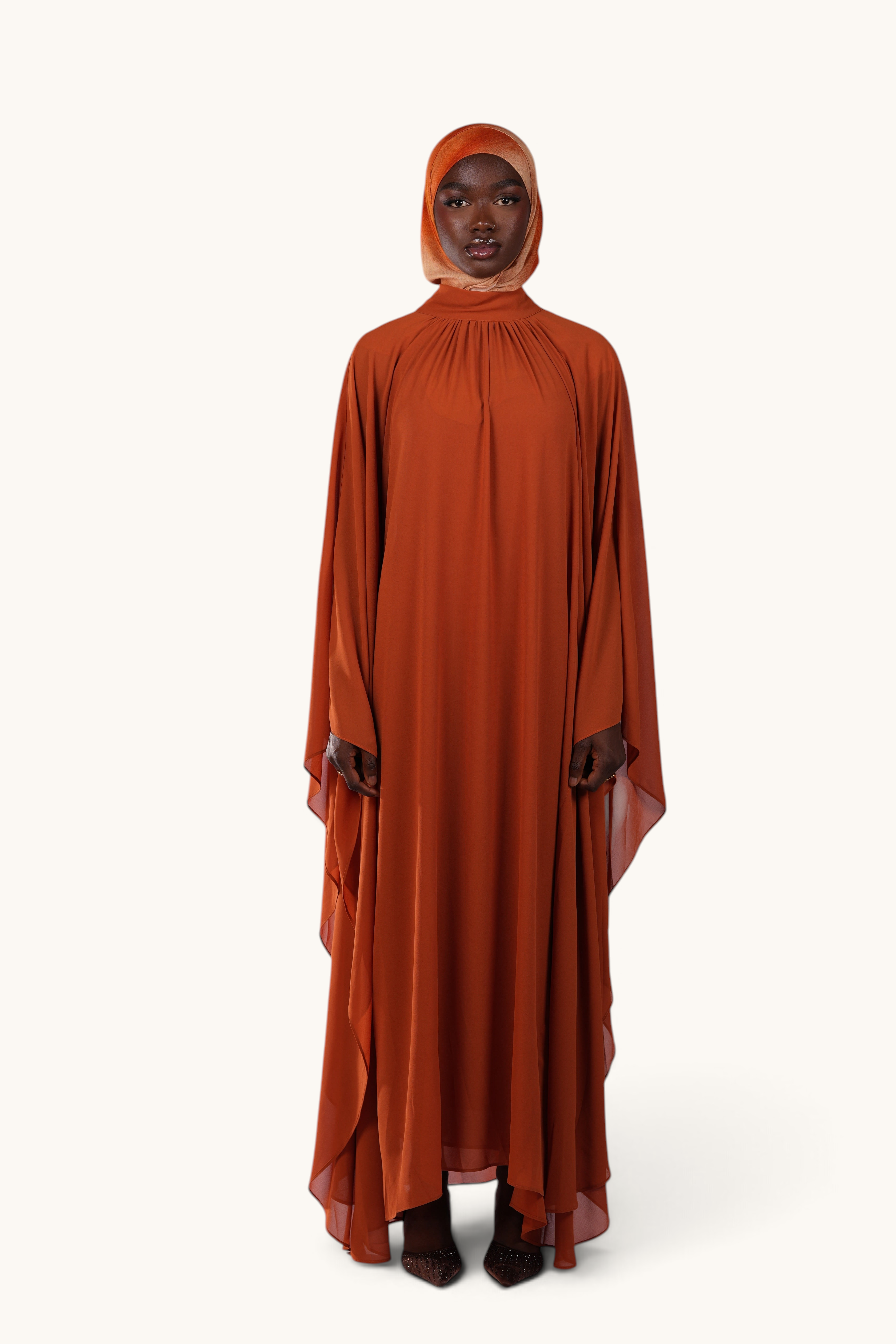 LOSYANA Andalusia sunset orange chiffon cape dress with matching hijab worn by a model on a white background.