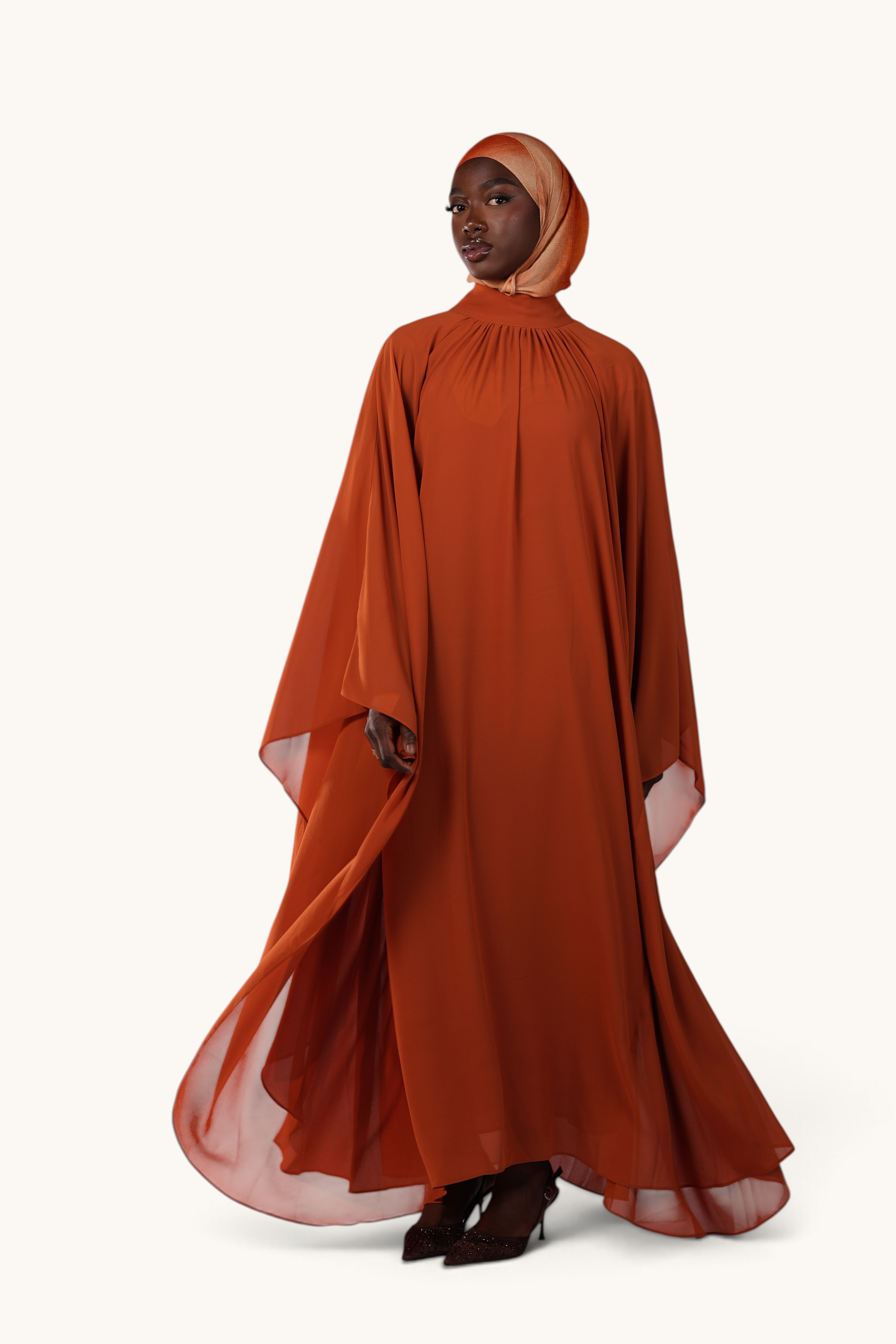 LOSYANA Andalusia sunset orange chiffon cape dress with matching hijab worn by a model on a white background