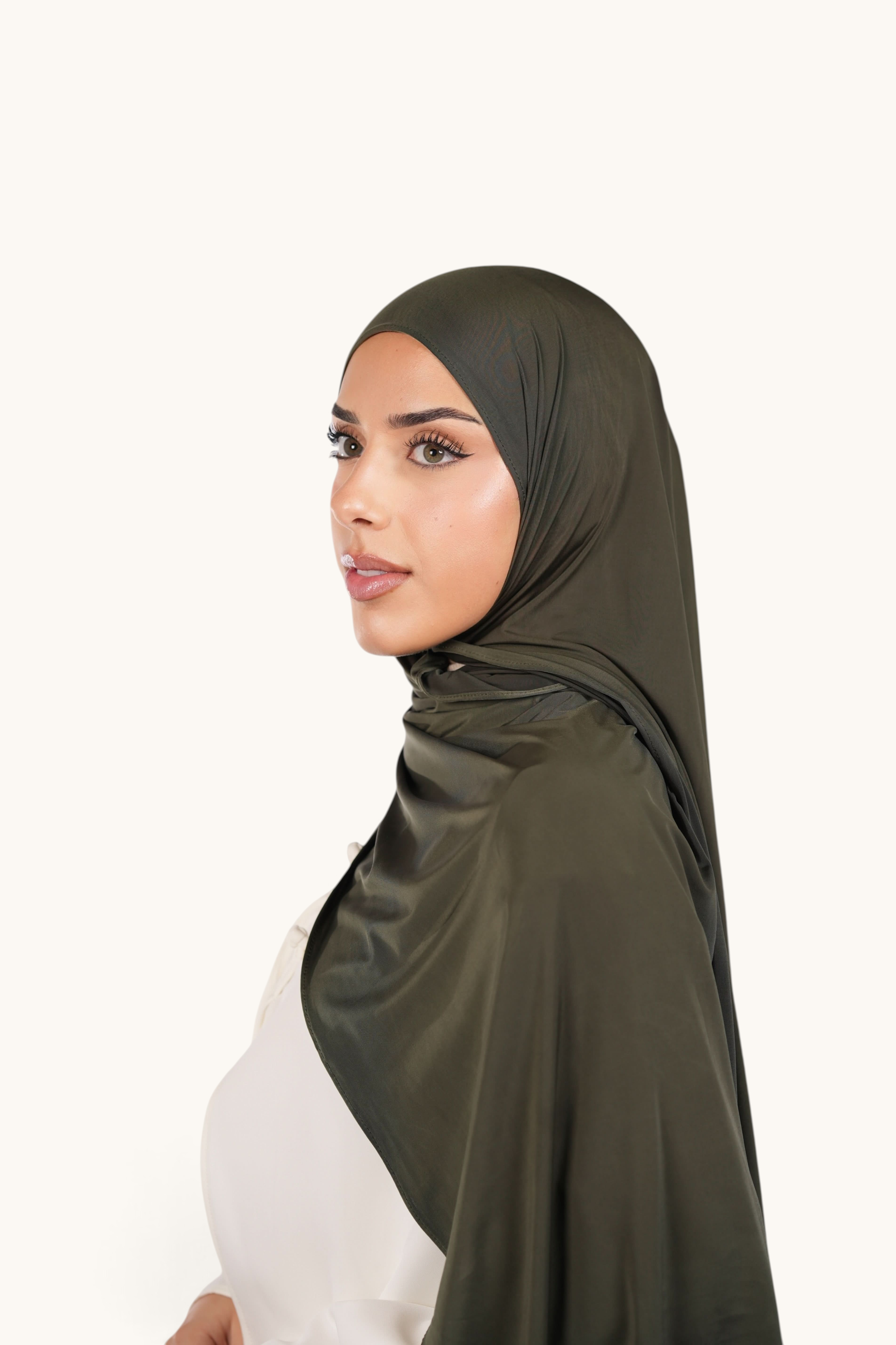 Model wearing a LOSYANA army green liquid jersey hijab with a subtle satin sheen, styled for an elegant look.
