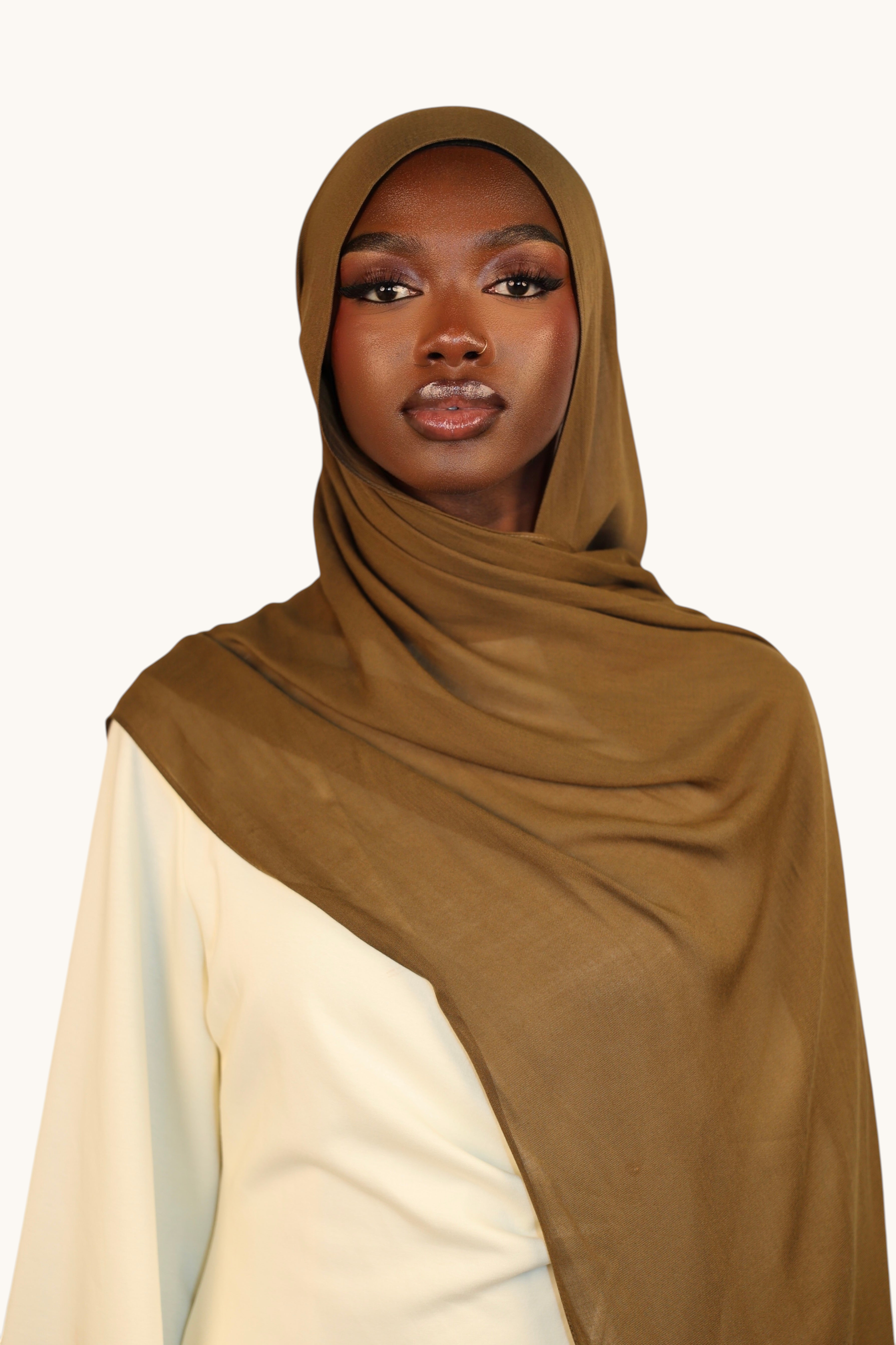 Model wearing a lightweight army green LOSYANA modal hijab with a soft, elegant drape and slight transparency.