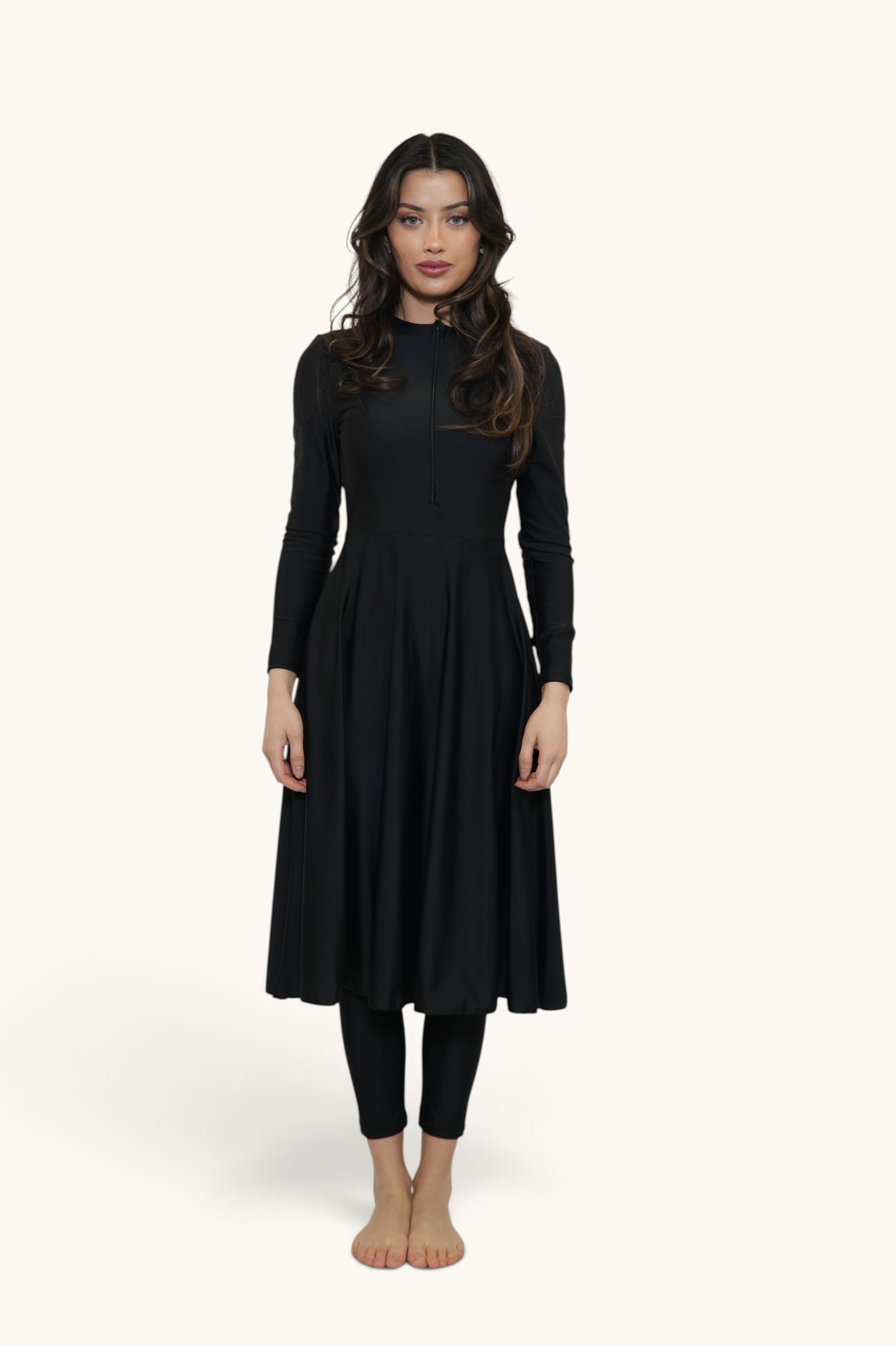 Model wearing a black LOSYANA Azzurra three-piece burkini set with a long-sleeved tunic and matching leggings.