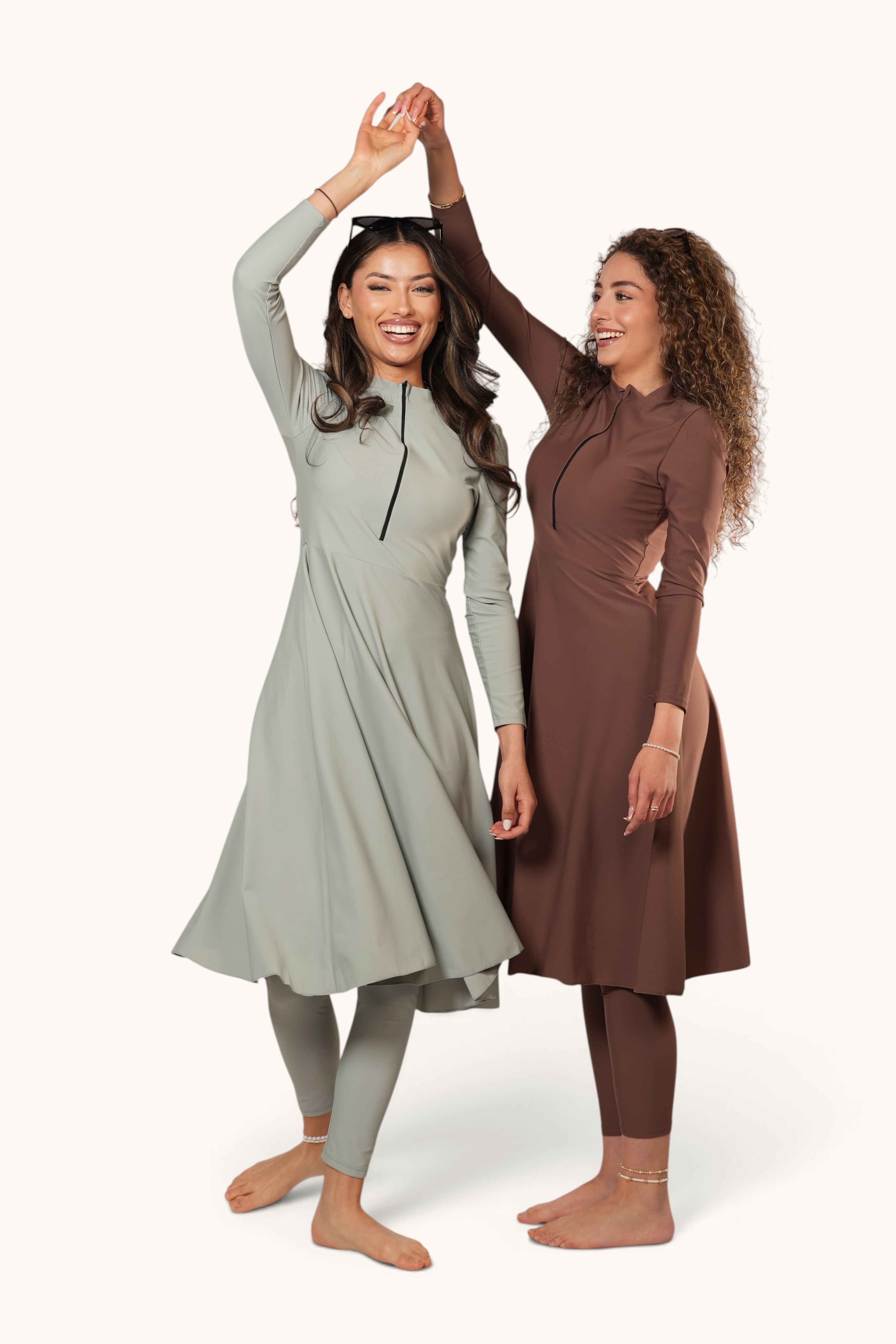 Two women wearing LOSYANA Azzurra burkini sets in sage green and brown with long tops and leggings