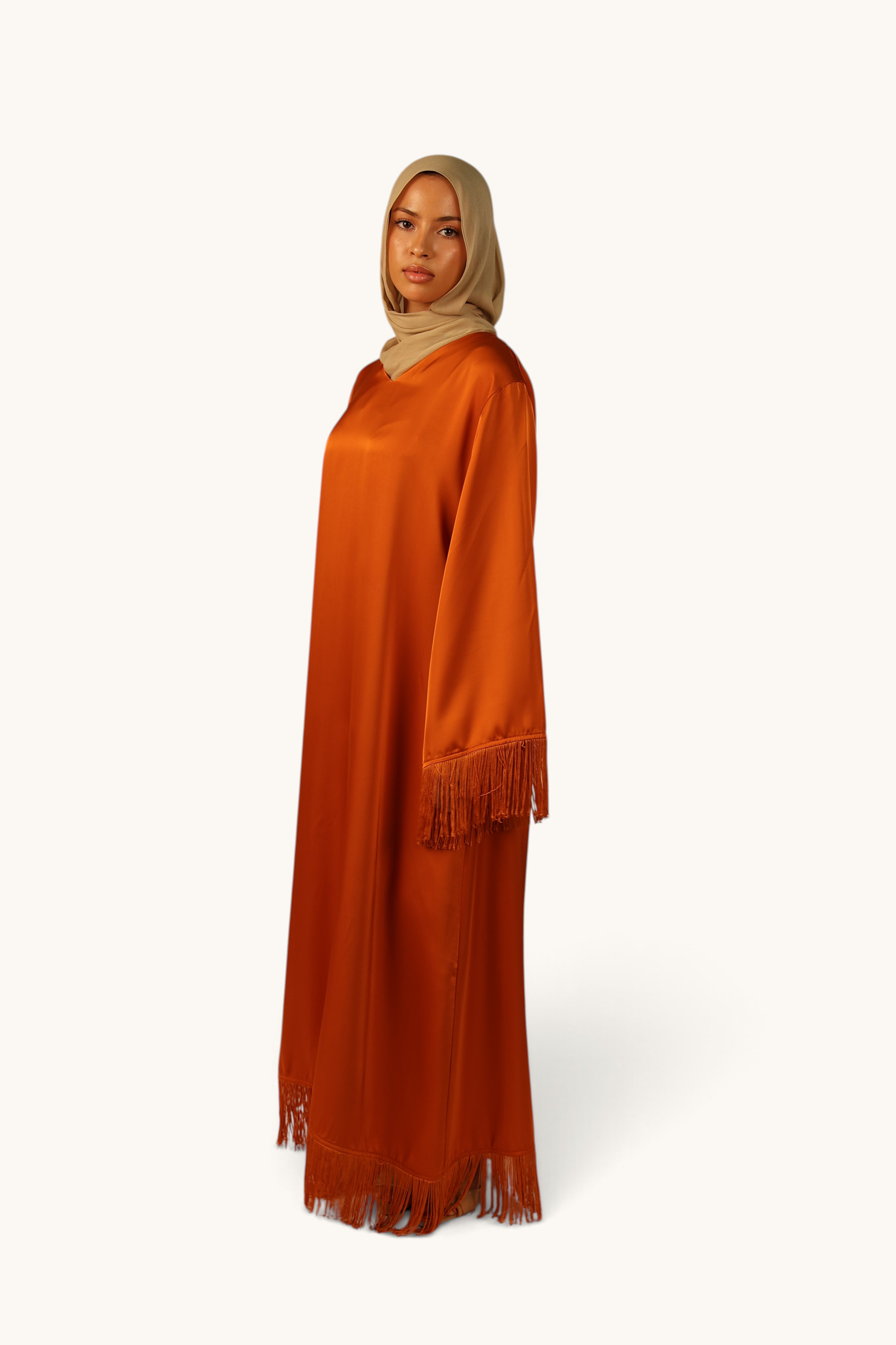 LOSYANA Barcelona Satin Kleid in Papaya mit Fransen an Ärmeln und Saum, getragen mit beigem Hijab