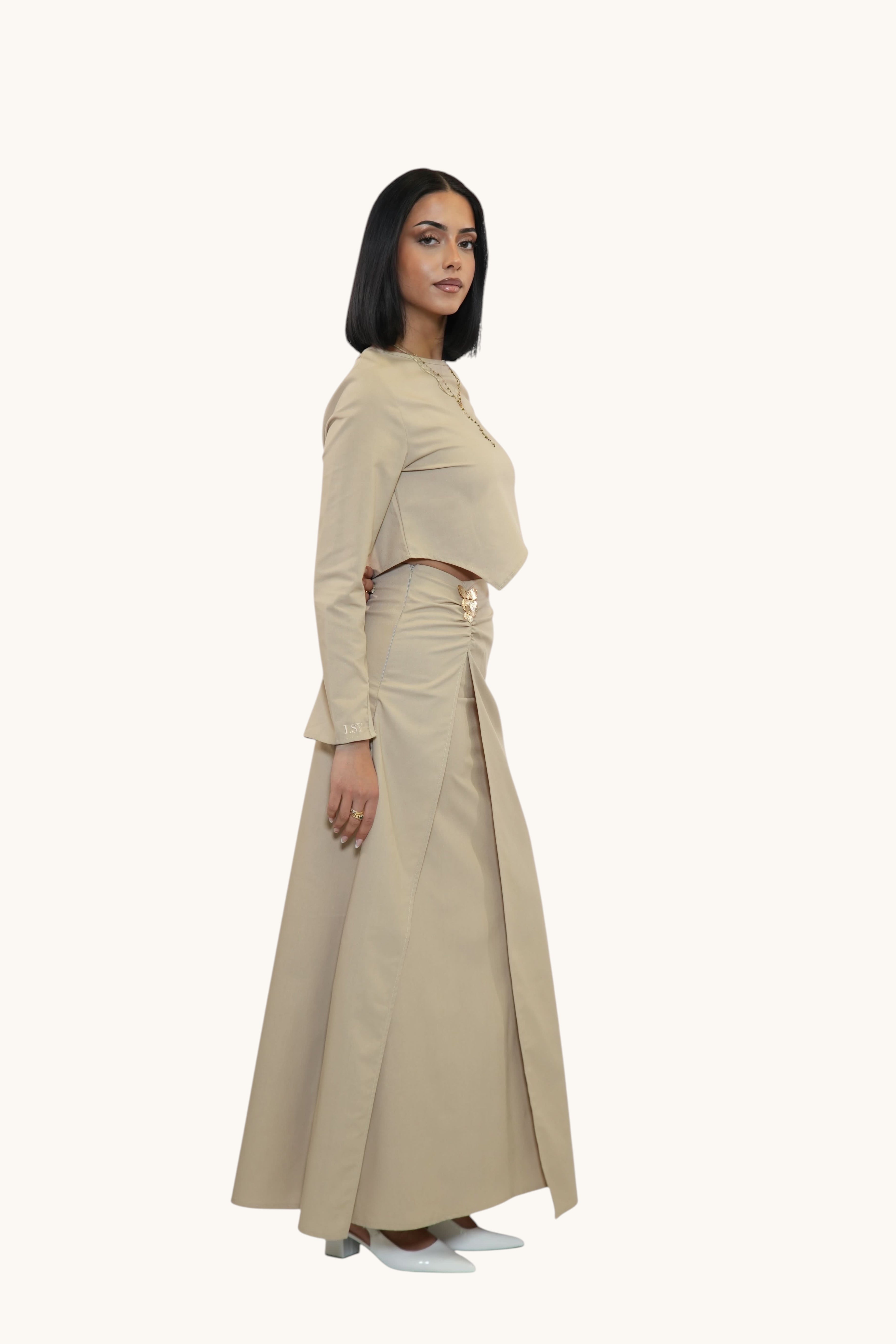 Model wearing LOSYANA beige linen-cotton blend long skirt and crop top set with a side slit and gold hardware detail.