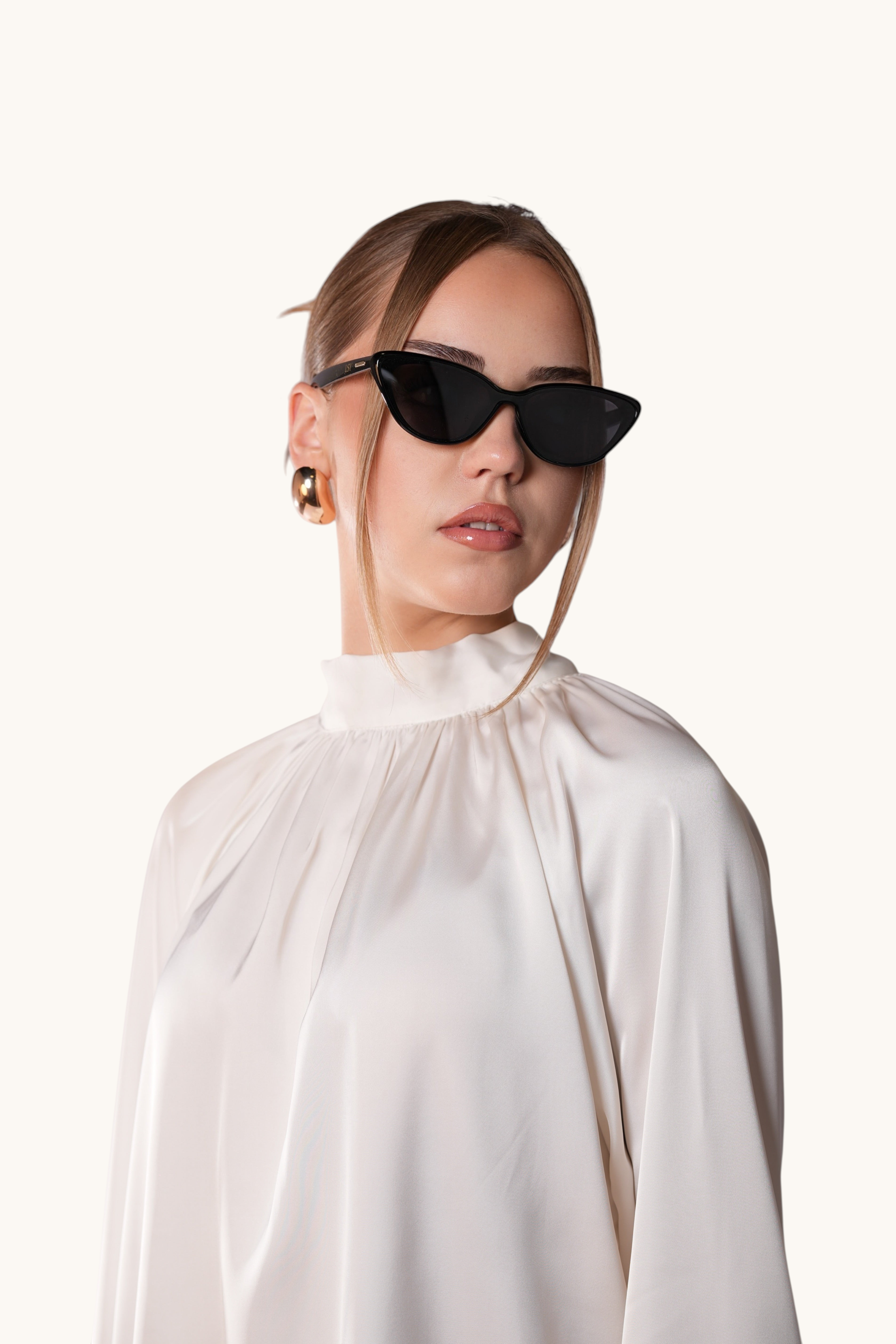 LOSYANA black cat-eye sunglasses worn by a woman in a white silk blouse, providing 100% UVA and UVB protection.