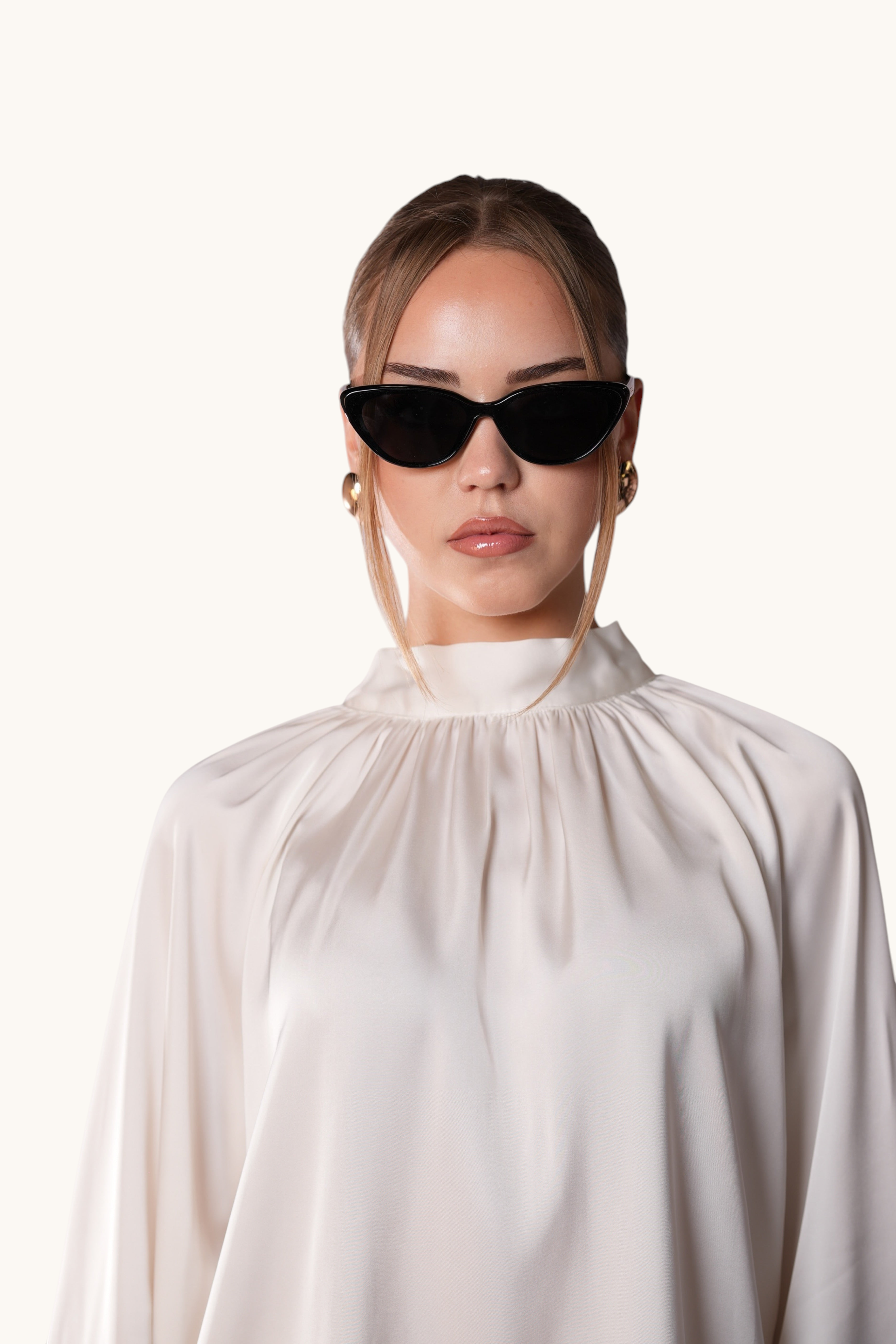 LOSYANA black cat-eye sunglasses worn by a woman in a cream satin blouse, providing UVA and UVB protection.
