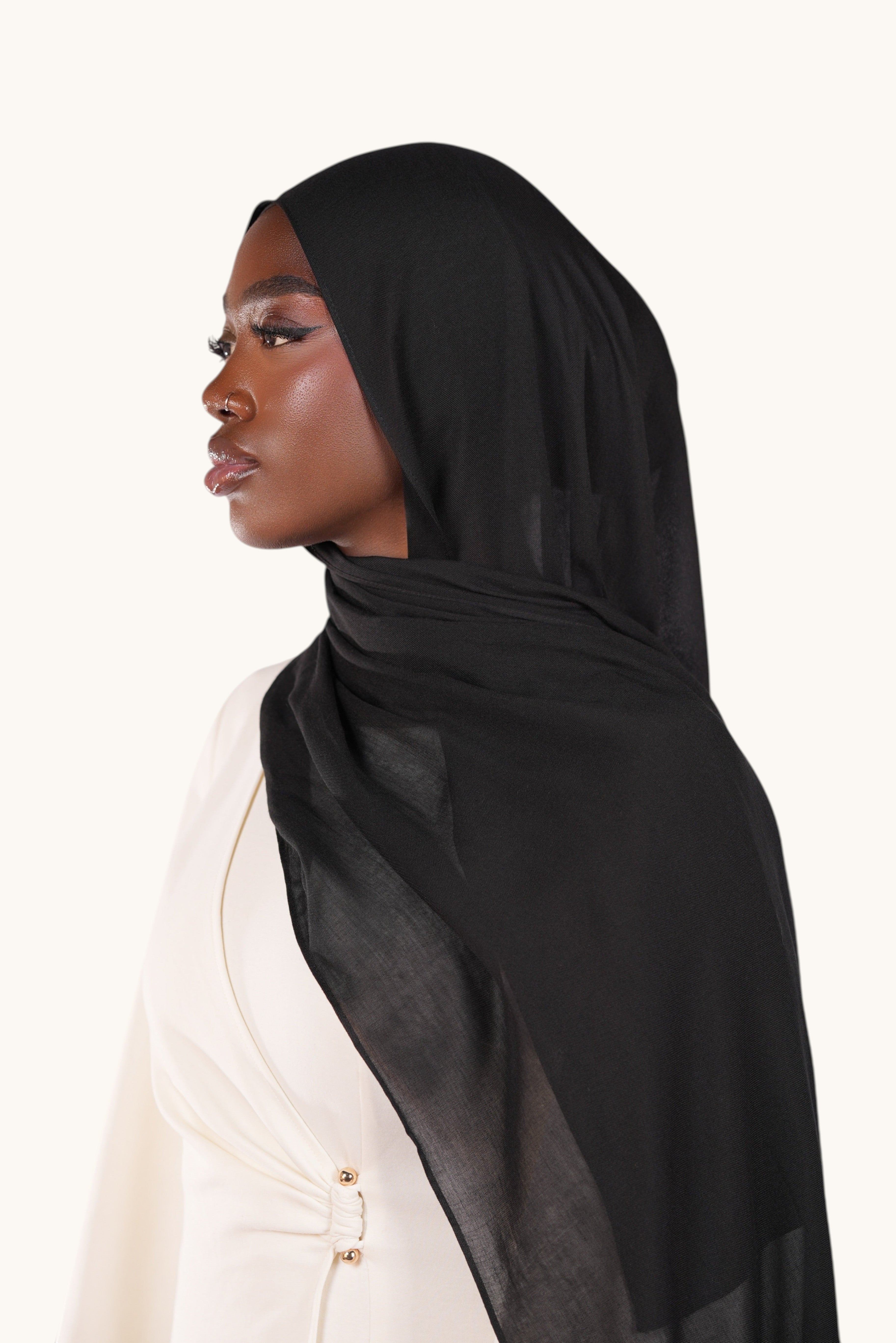 Model wearing a lightweight black LOSYANA modal hijab with a soft, elegant drape against a neutral background.