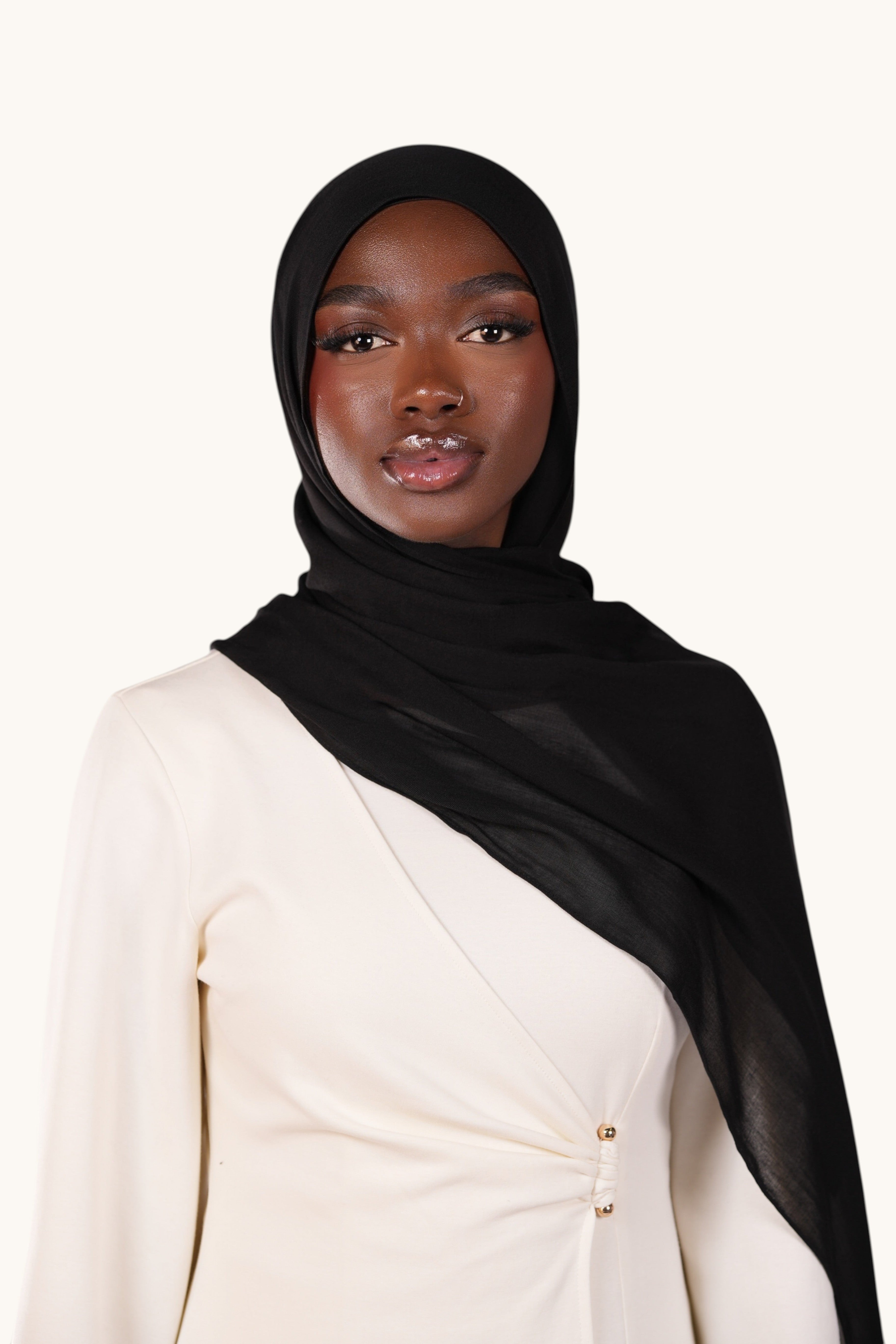 Model wearing a black LOSYANA lightweight modal hijab with a matching undercap, featuring a soft flowing drape.