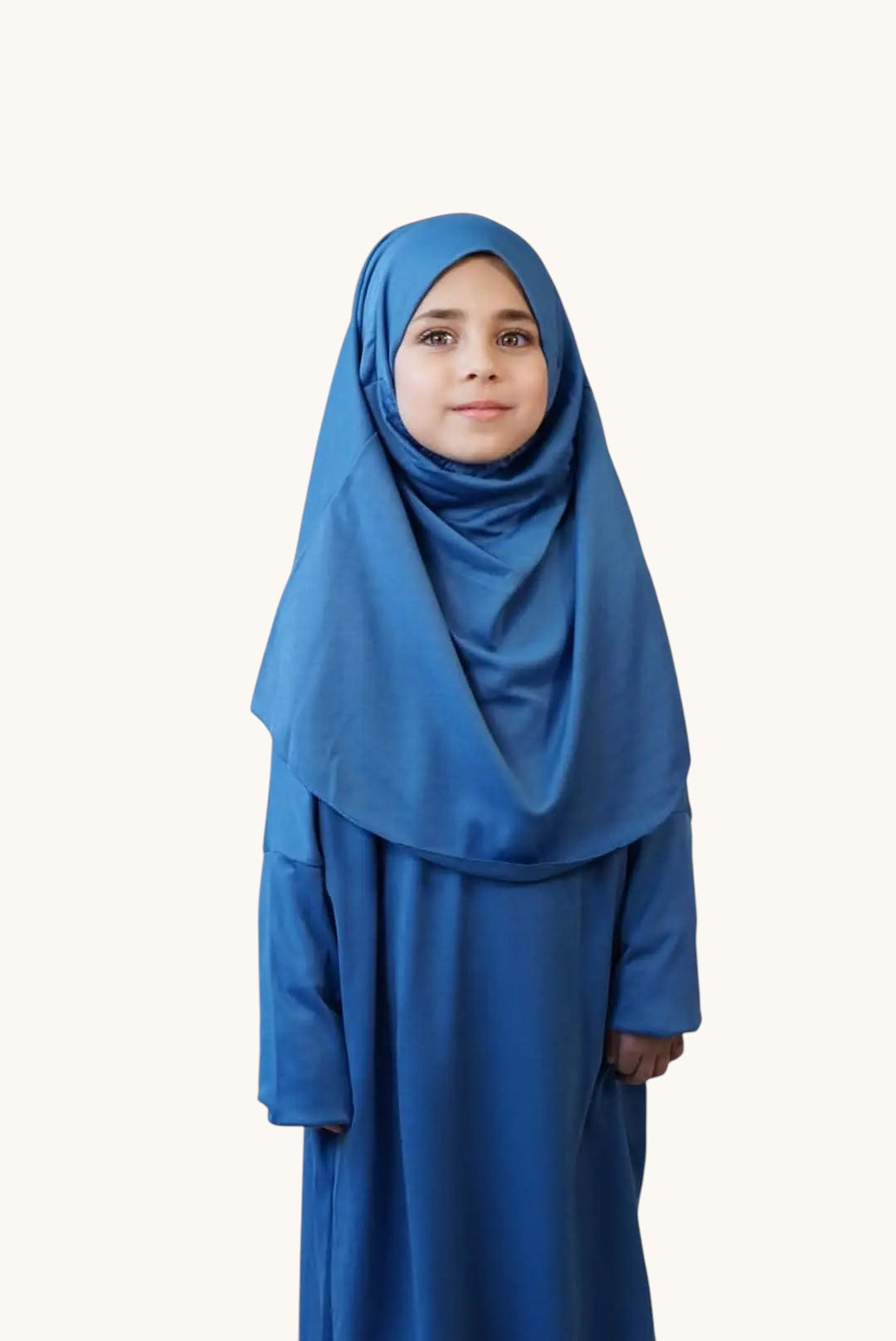 Young girl wearing a blue LOSYANA jersey prayer dress with a matching hijab for comfortable daily worship.