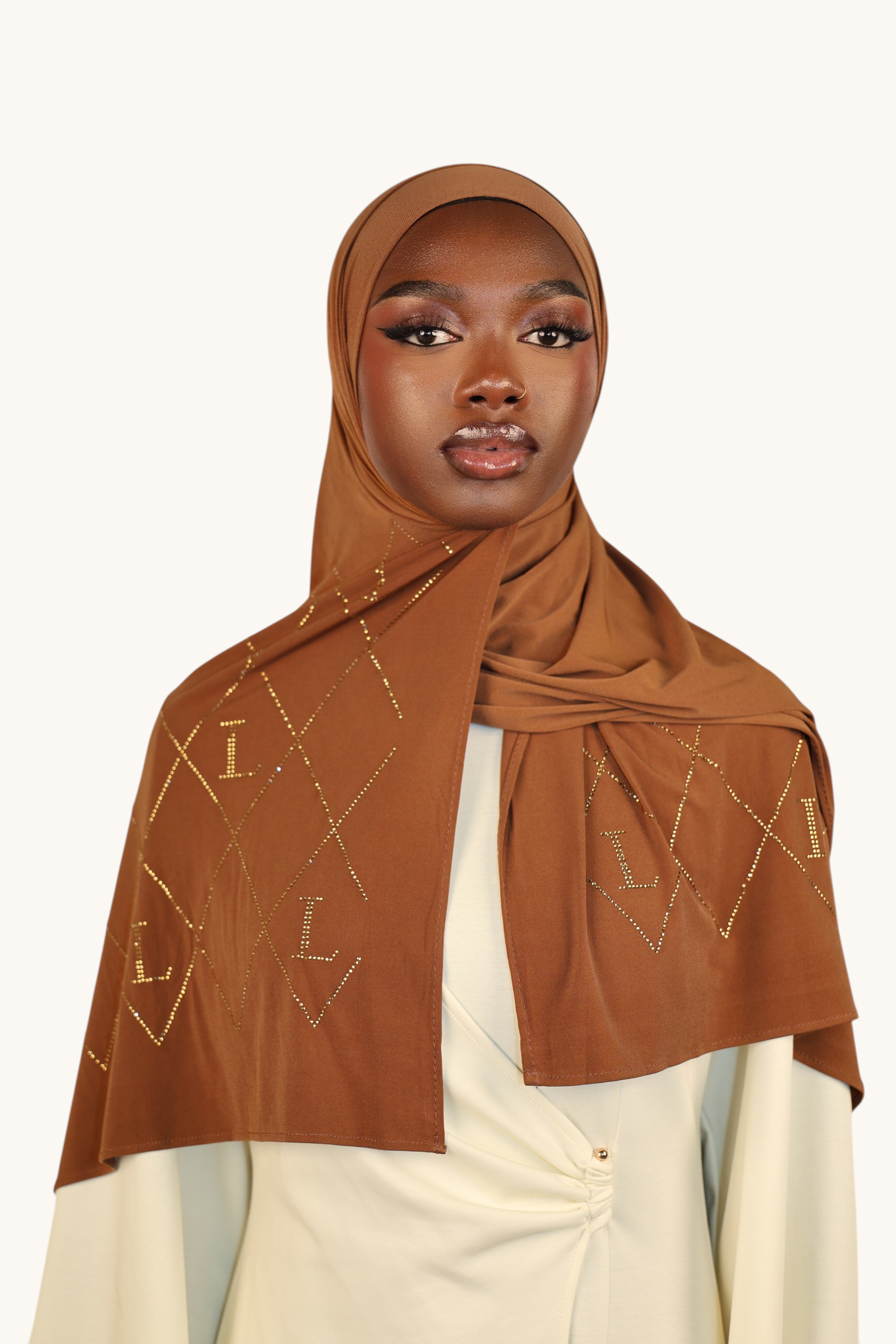 Model wearing a bronze LOSYANA premium jersey hijab decorated with sparkling rhinestone L patterns