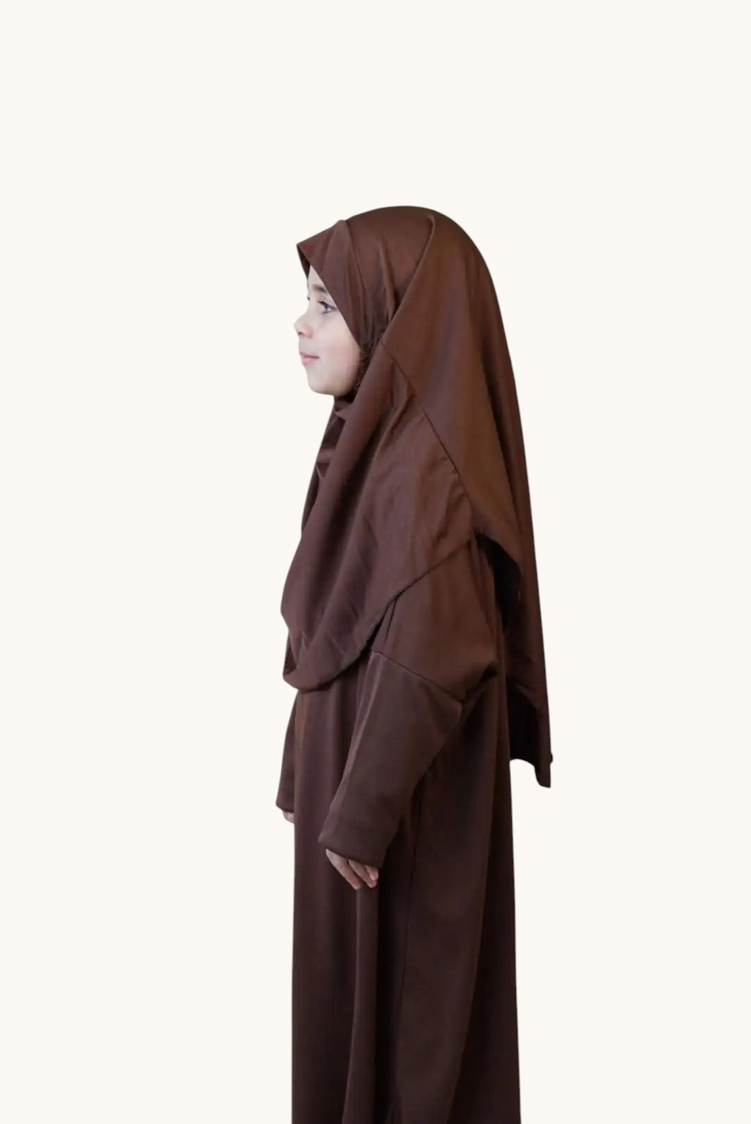 LOSYANA child wearing a soft brown jersey prayer dress with an integrated hijab, side profile view