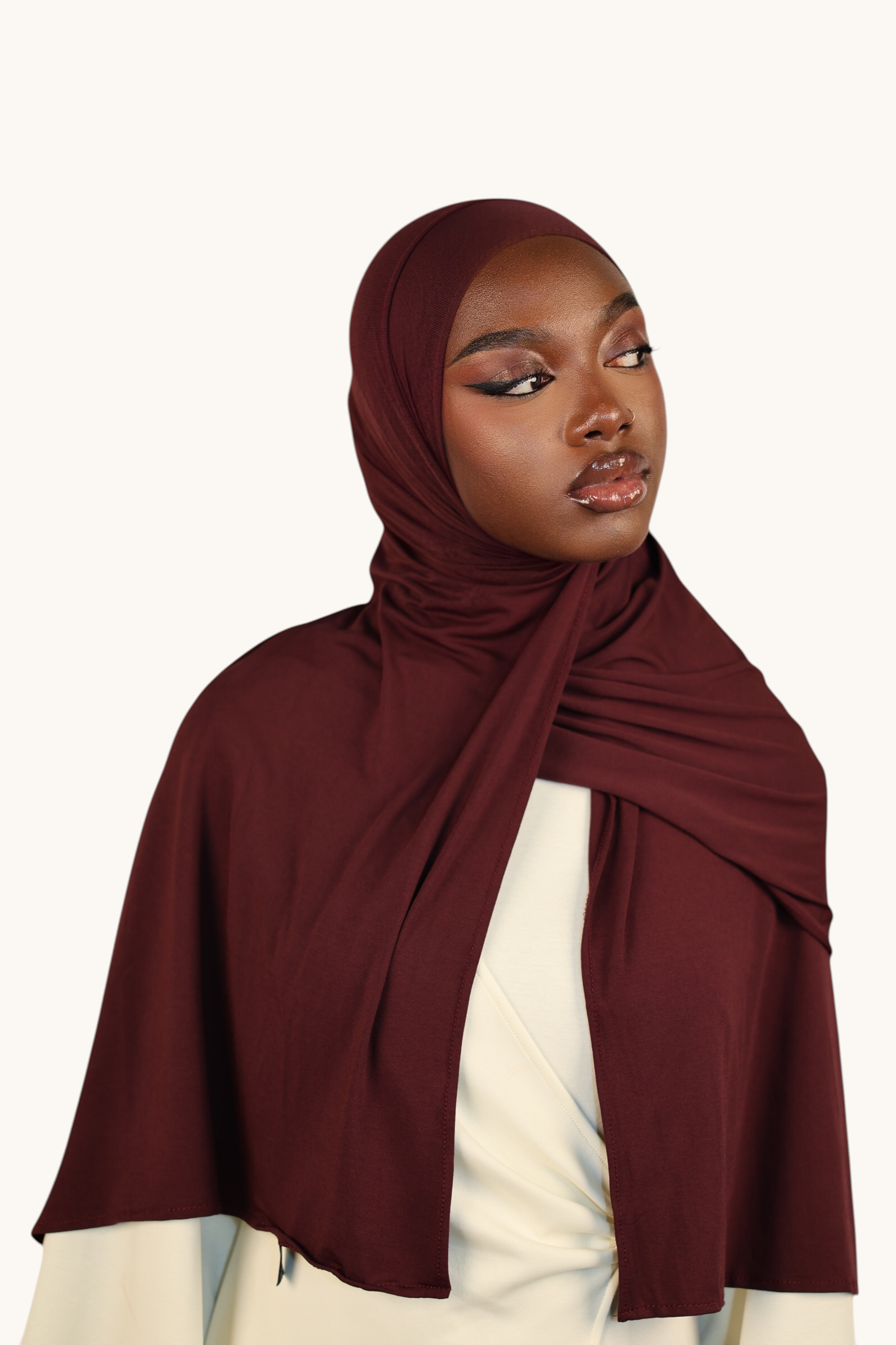 Model wearing a burgundy LOSYANA Vela Jersey hijab made of soft, breathable fabric, styled elegantly.