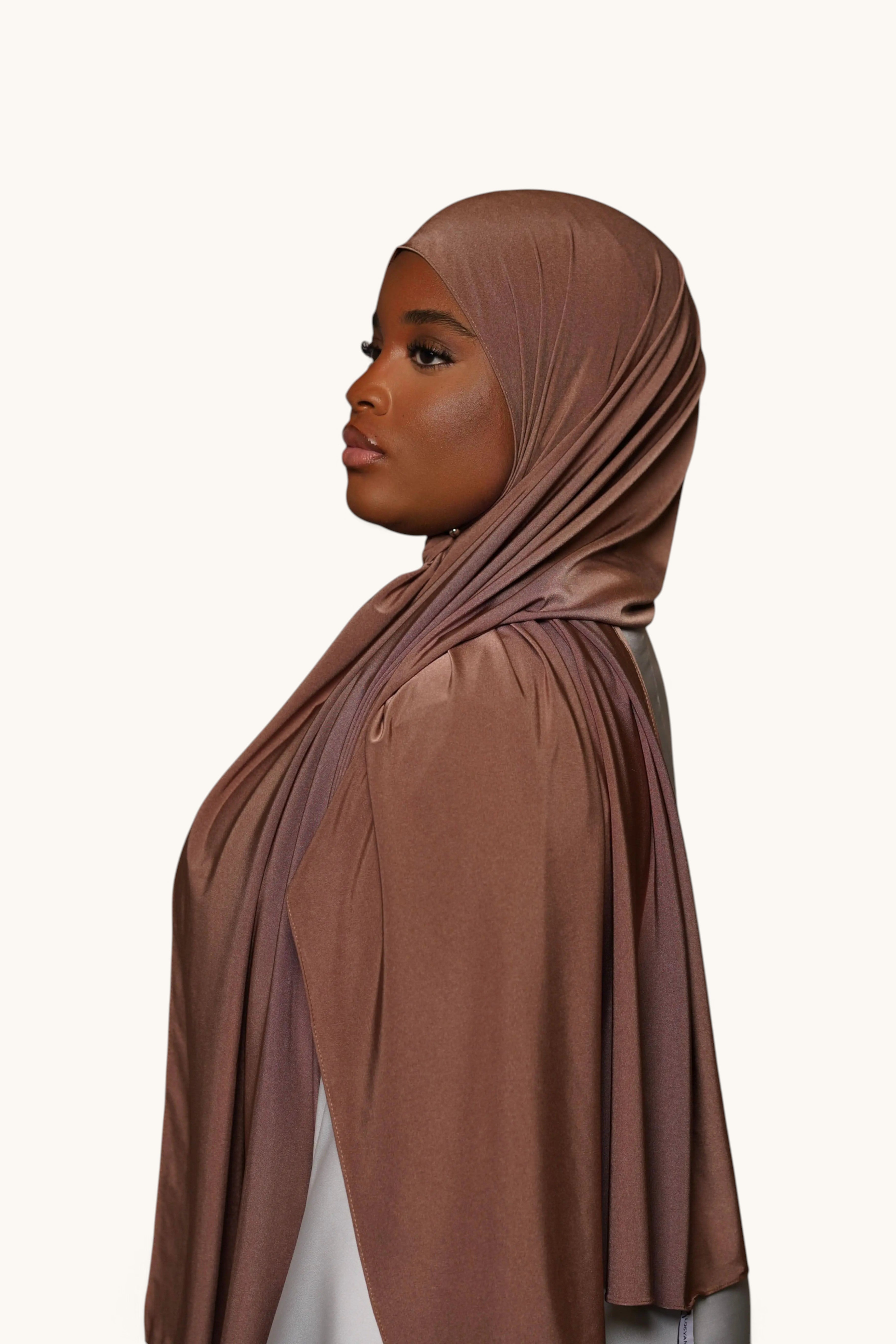 LOSYANA burnt sugar satin jersey hijab worn by a model, featuring a smooth, non-slip, and opaque draped fabric.