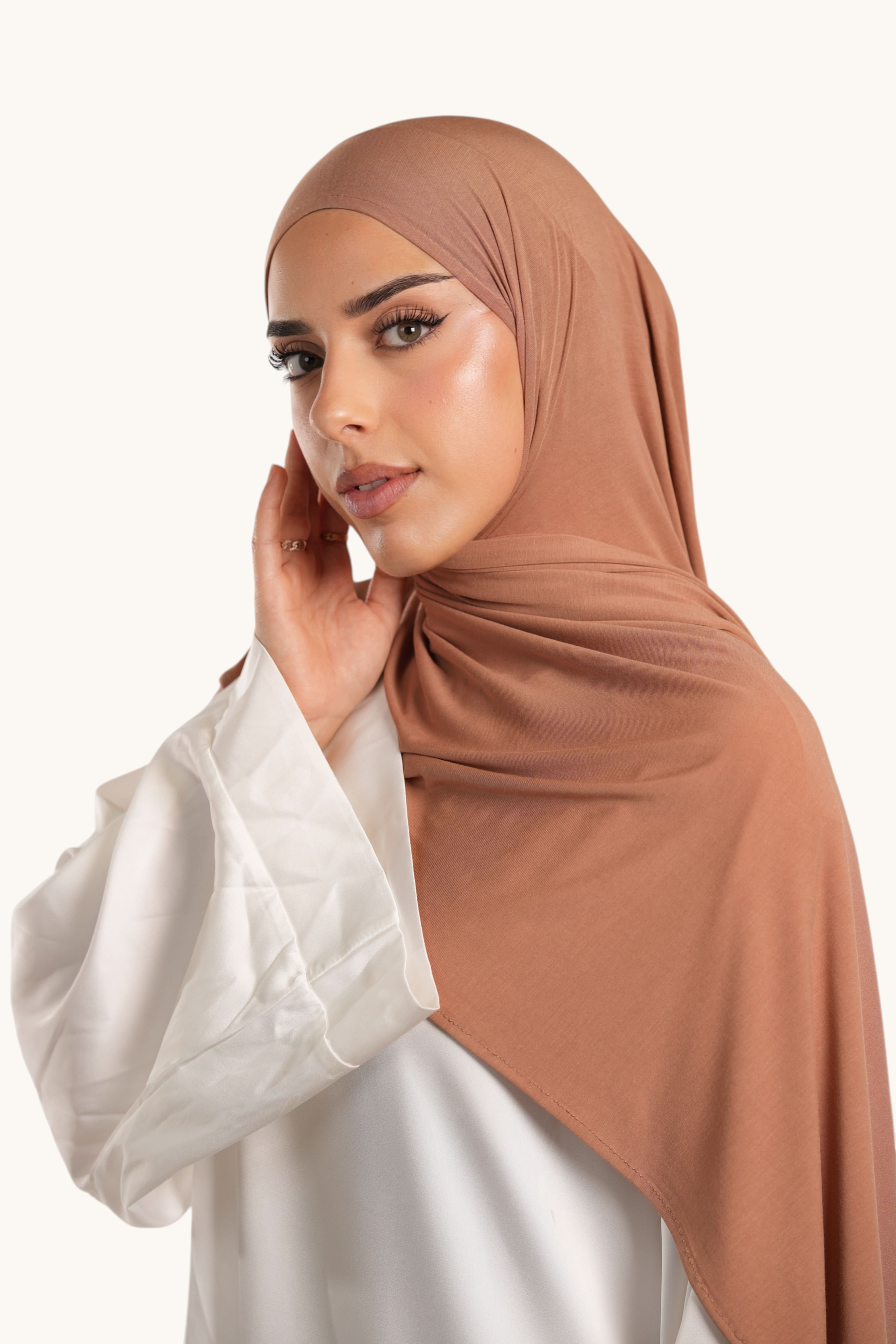 Model wearing a caramel LOSYANA Vela Jersey hijab, crafted from soft, lightweight, breathable fabric.