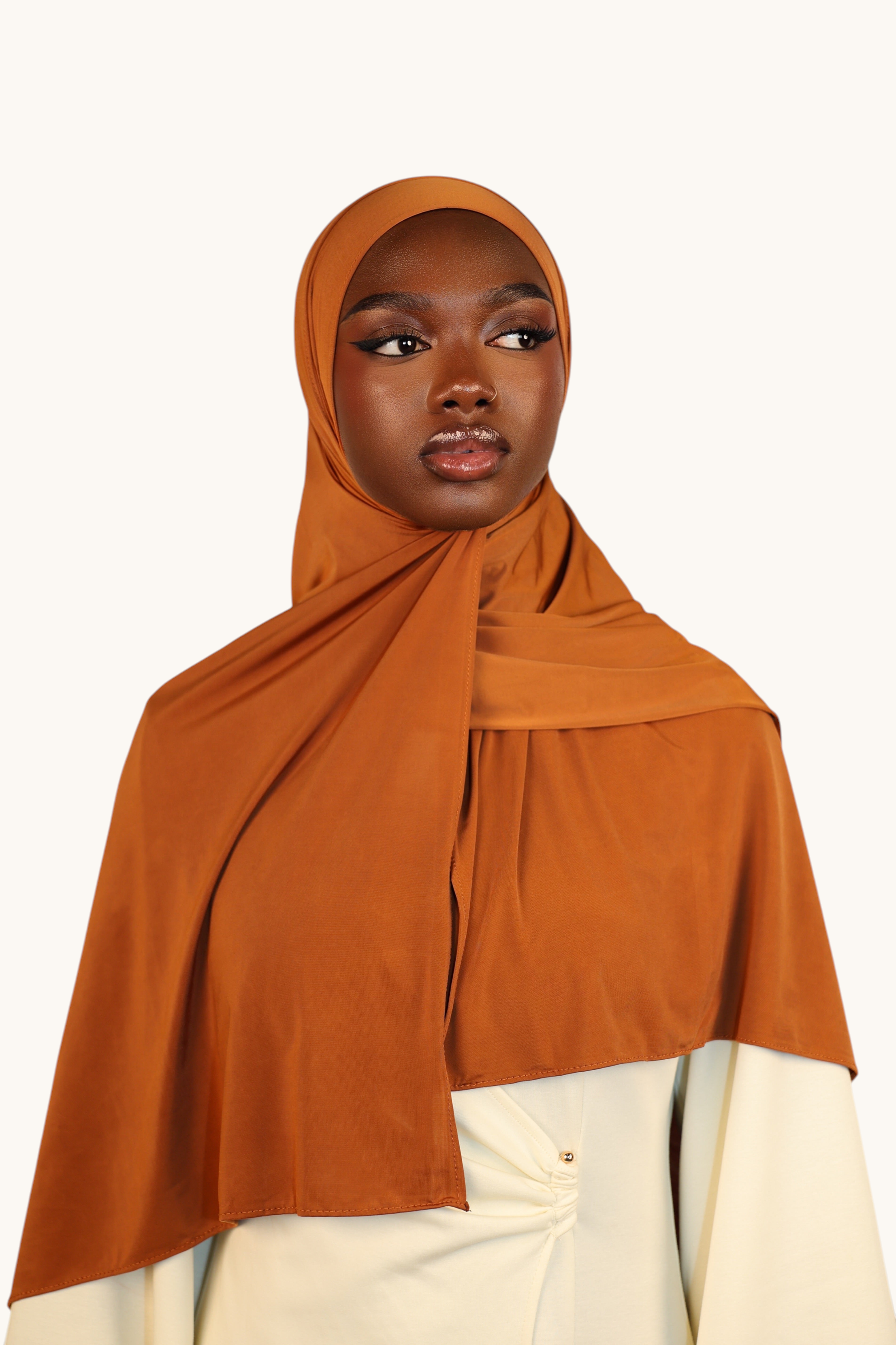 Model wearing a LOSYANA copper liquid jersey hijab with a subtle sheen, styled for an elegant and breathable look.