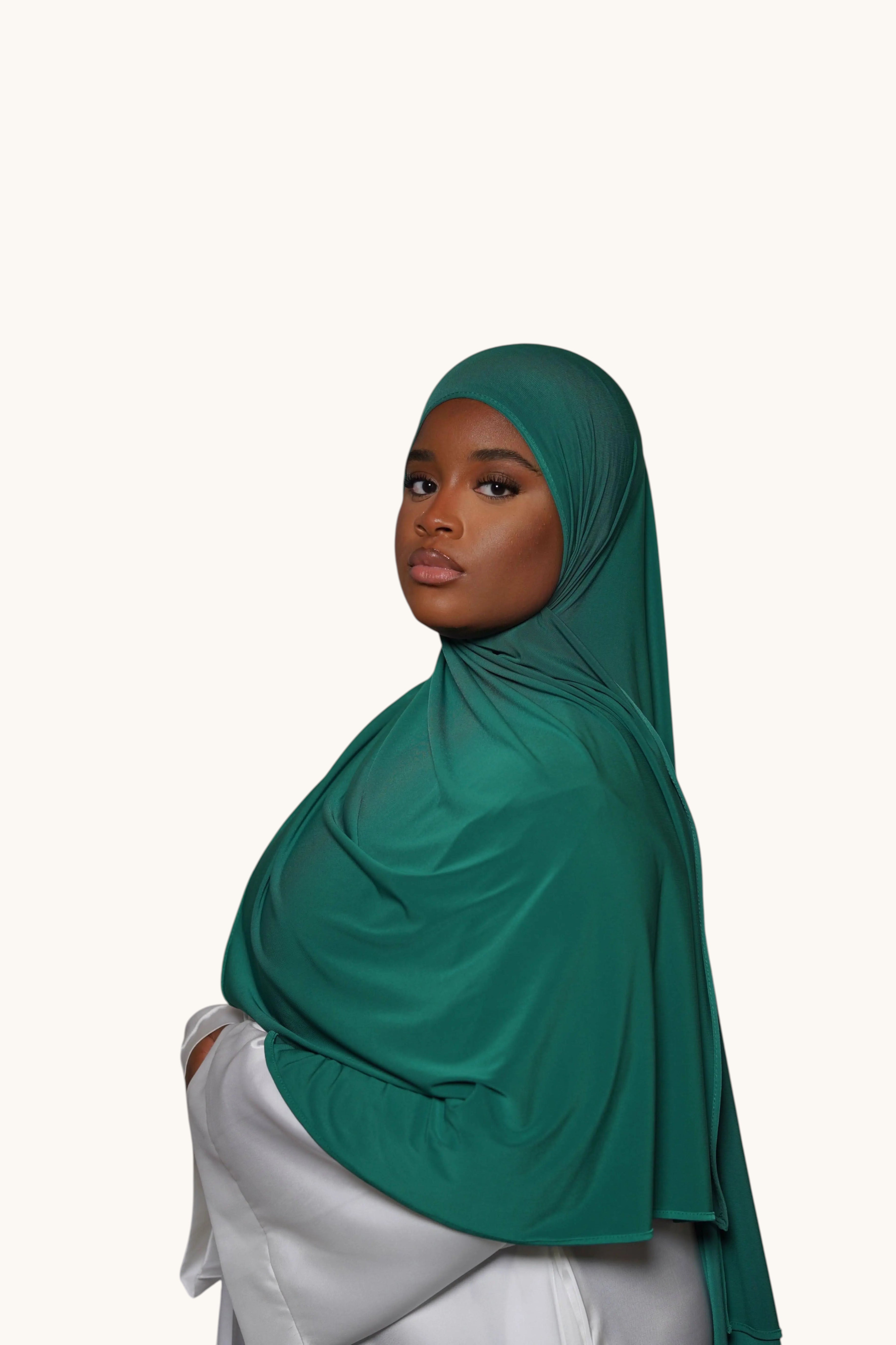 Model wearing a dark green LOSYANA premium jersey hijab, featuring soft, non-transparent, and non-slip fabric.