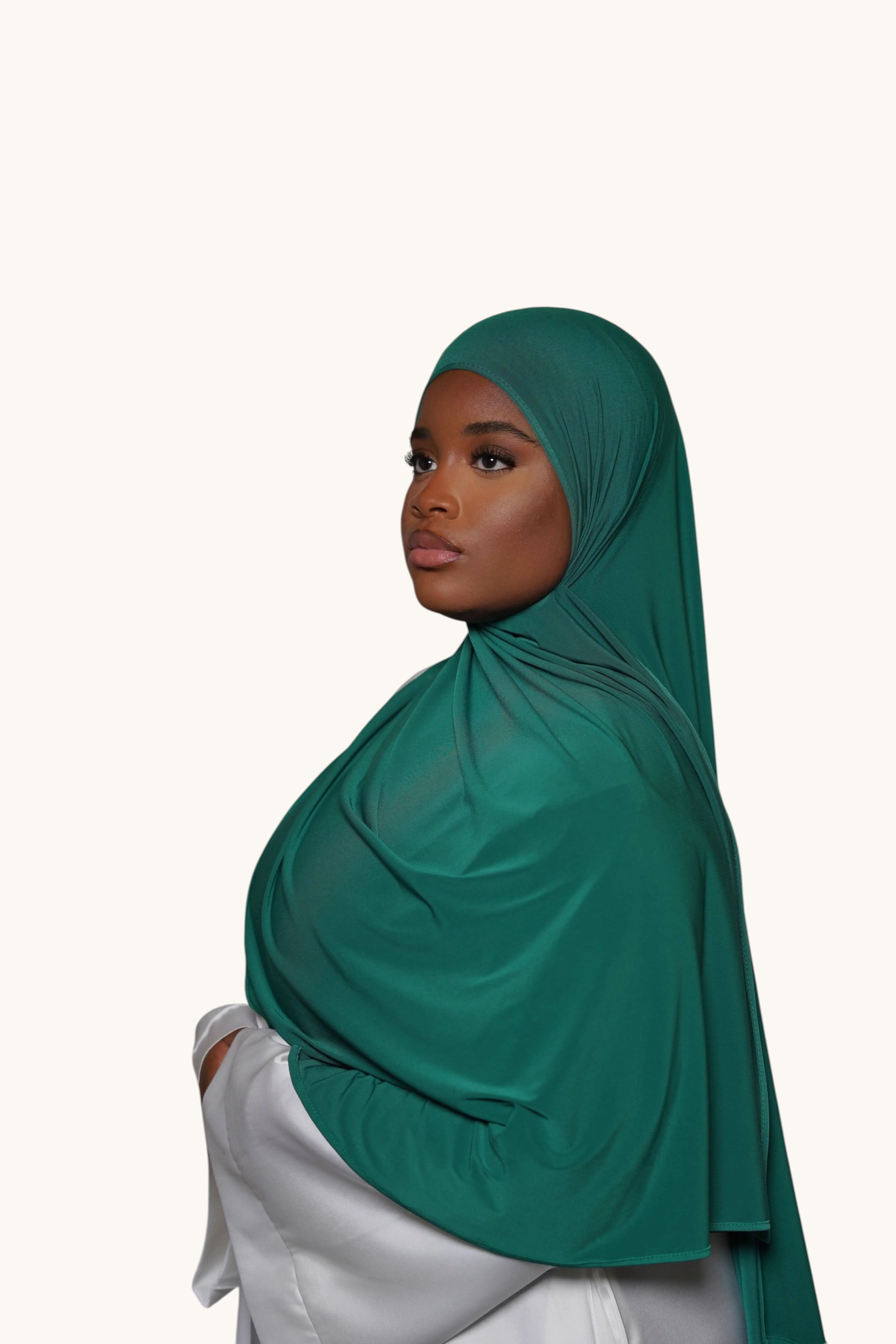 Model wearing a dark green LOSYANA premium jersey hijab, featuring a soft, non-transparent, and non-slip fabric.