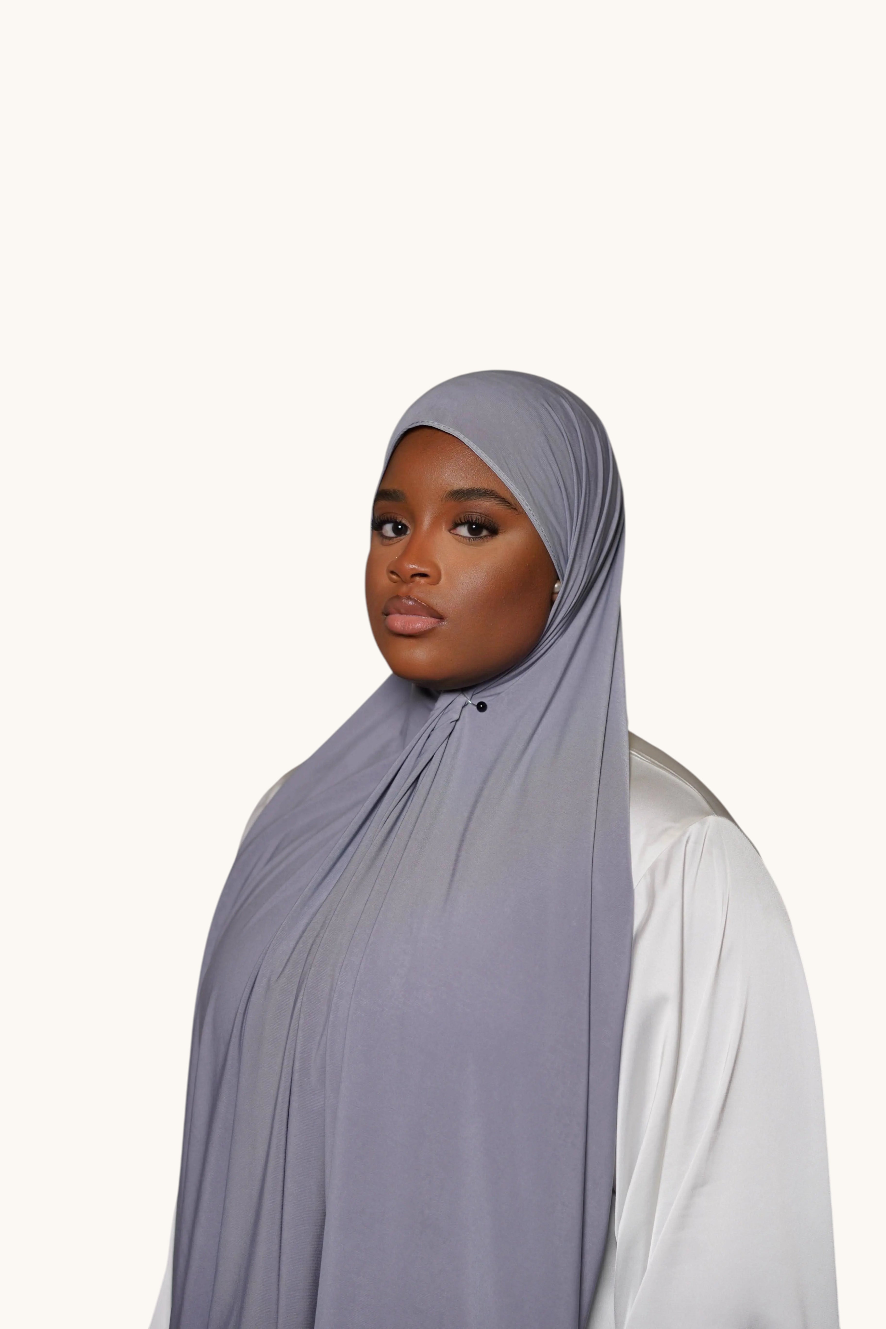 Model wearing a dark grey LOSYANA premium jersey hijab, featuring a soft, non-slip, and opaque fabric drape.
