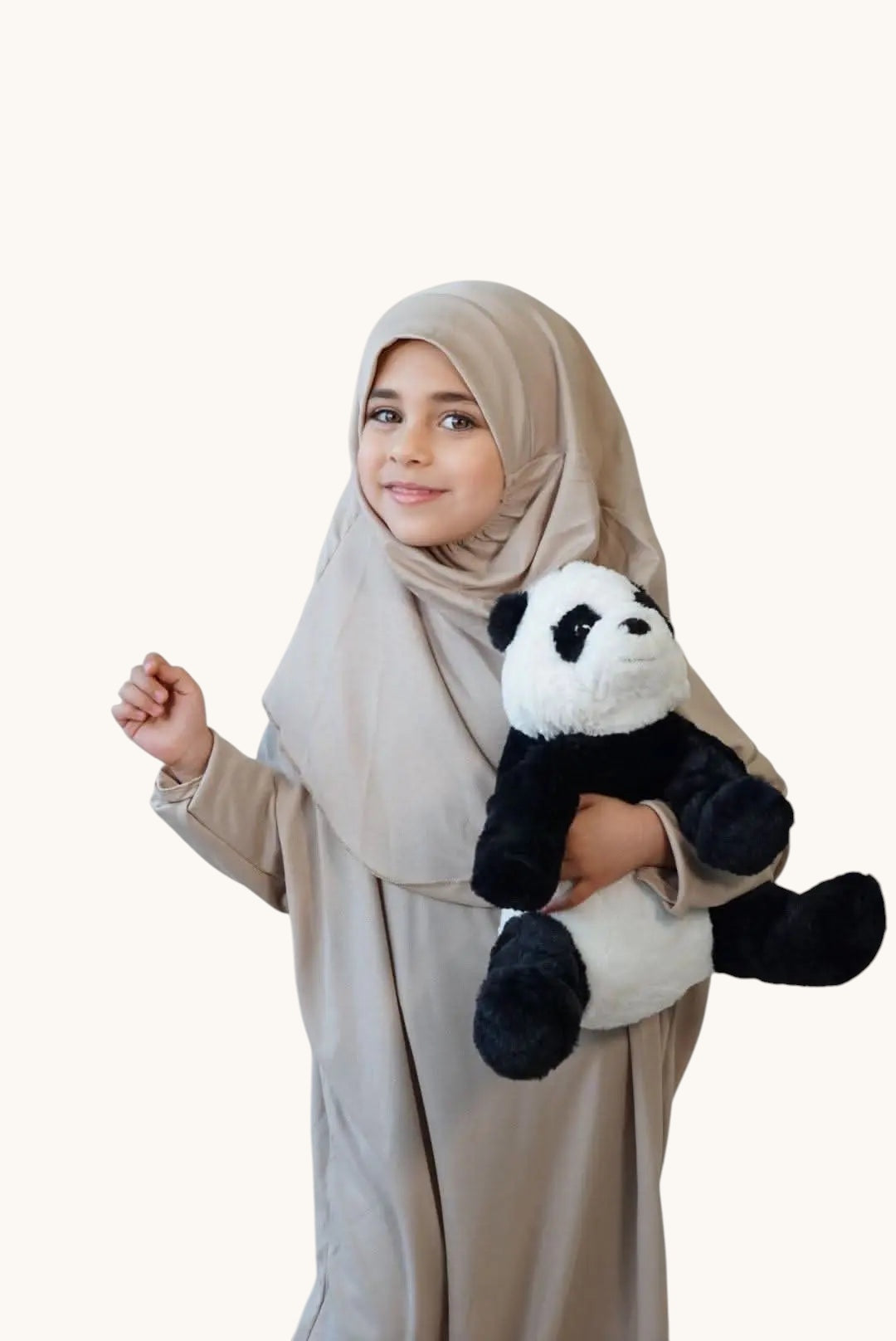 LOSYANA desert beige jersey prayer dress for children worn by a young girl holding a plush panda toy