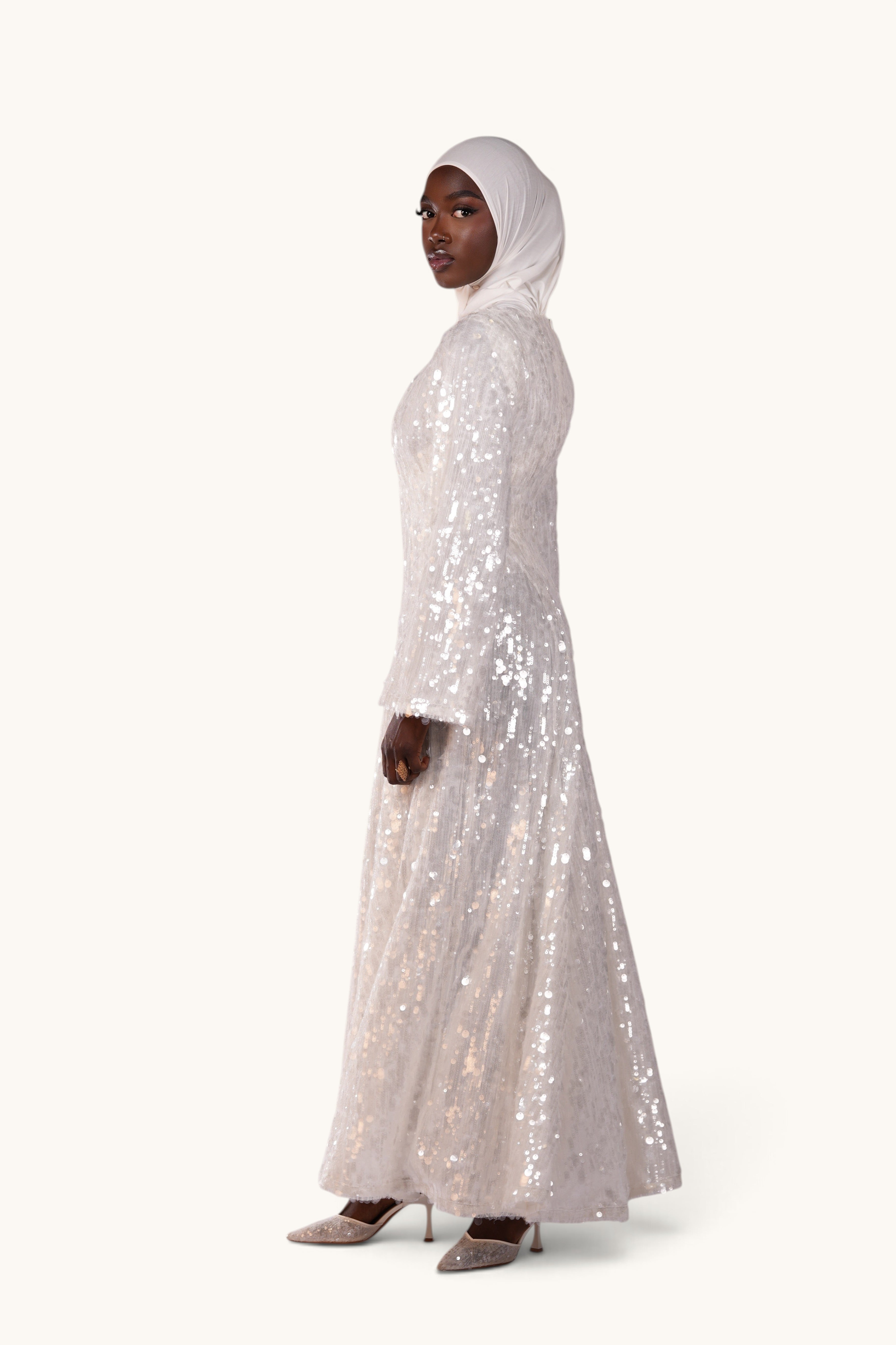 LOSYANA Formentera white sequin A-line evening dress with trumpet sleeves worn by a model in a hijab