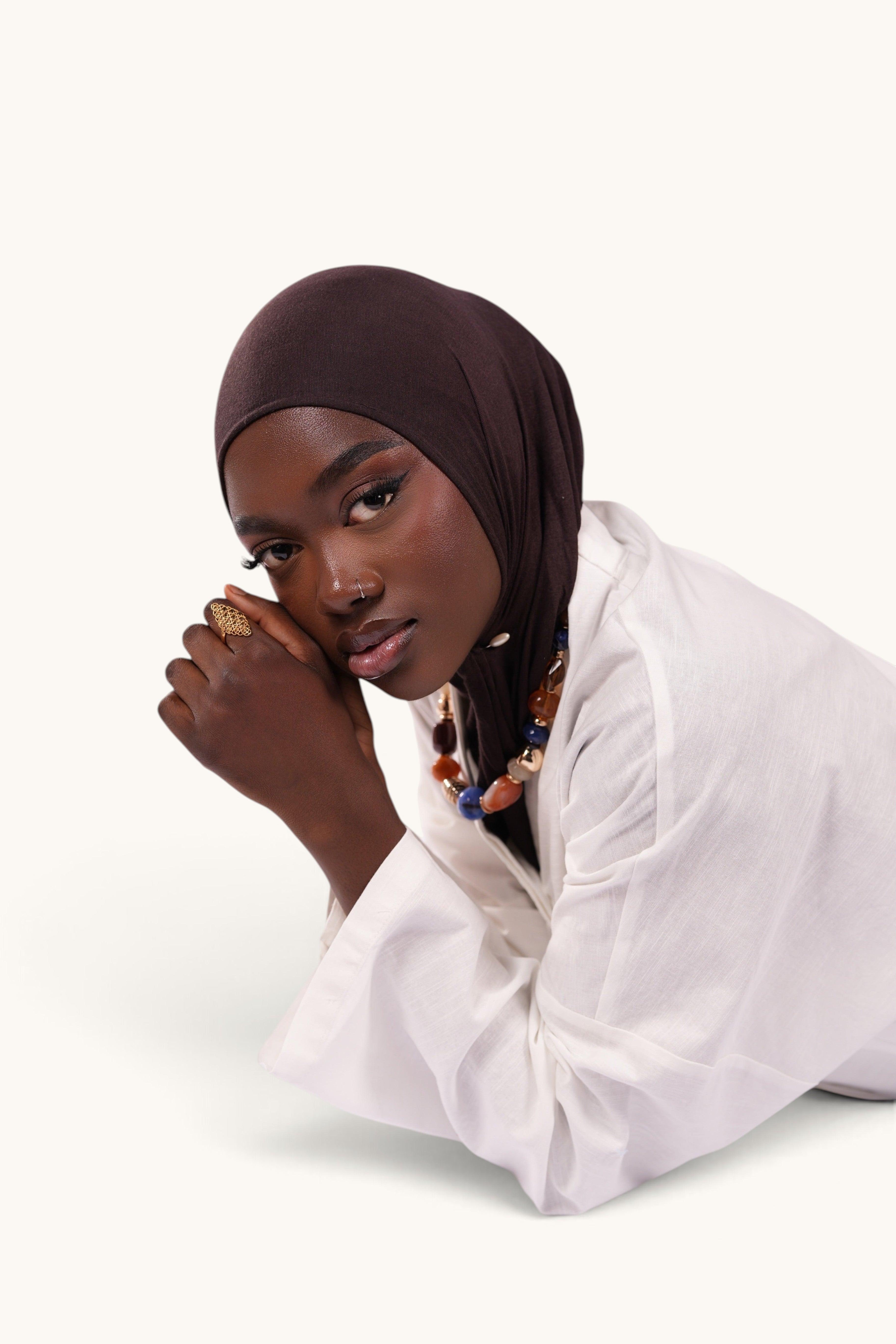 LOSYANA Gran Canaria white linen two-piece set with trumpet sleeves worn by a model in a dark brown hijab