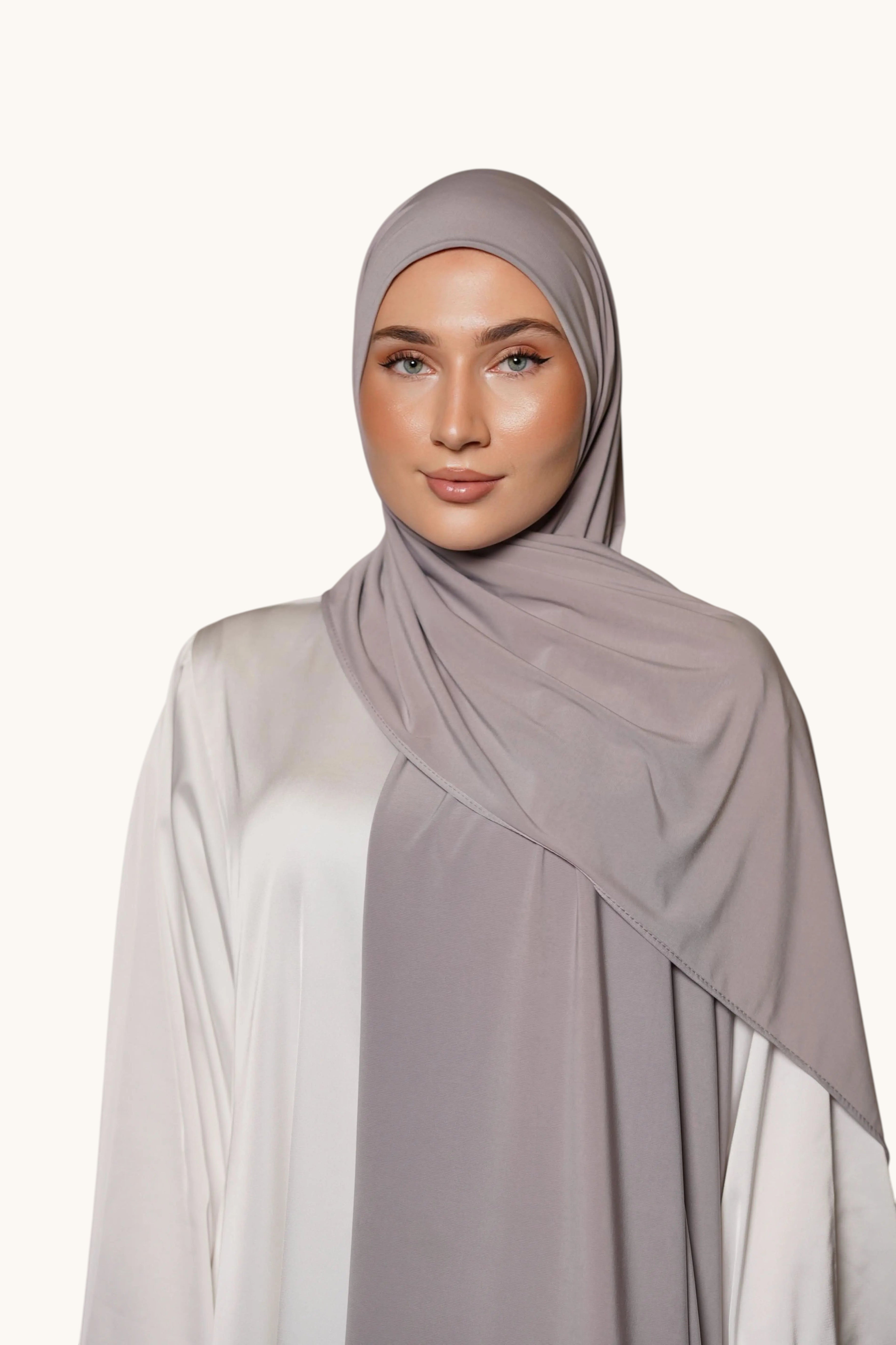 Model wearing a soft grey LOSYANA premium jersey hijab, featuring a non-slip, opaque, and comfortable fabric drape.