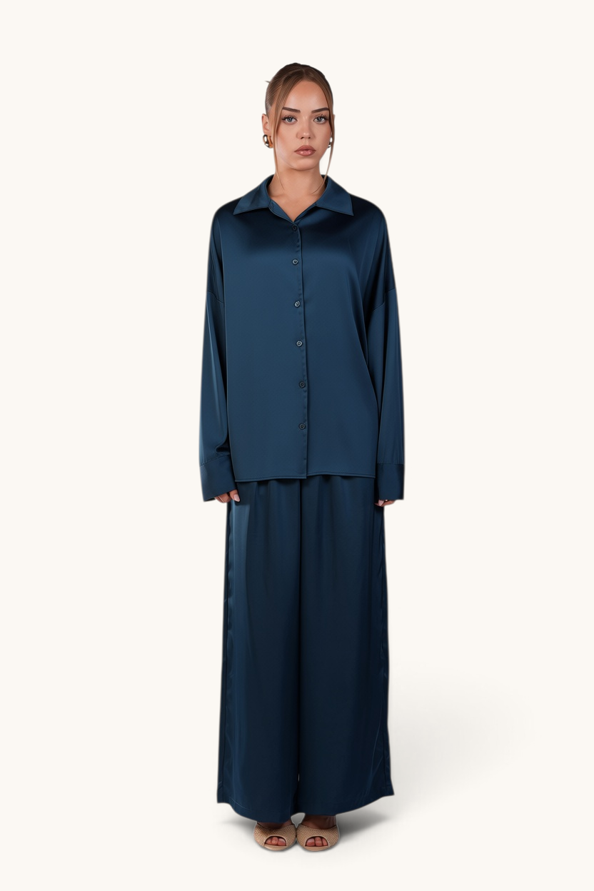 Model wearing LOSYANA La Laguna teal satin two-piece set with long-sleeve button-down blouse and wide-leg trousers.