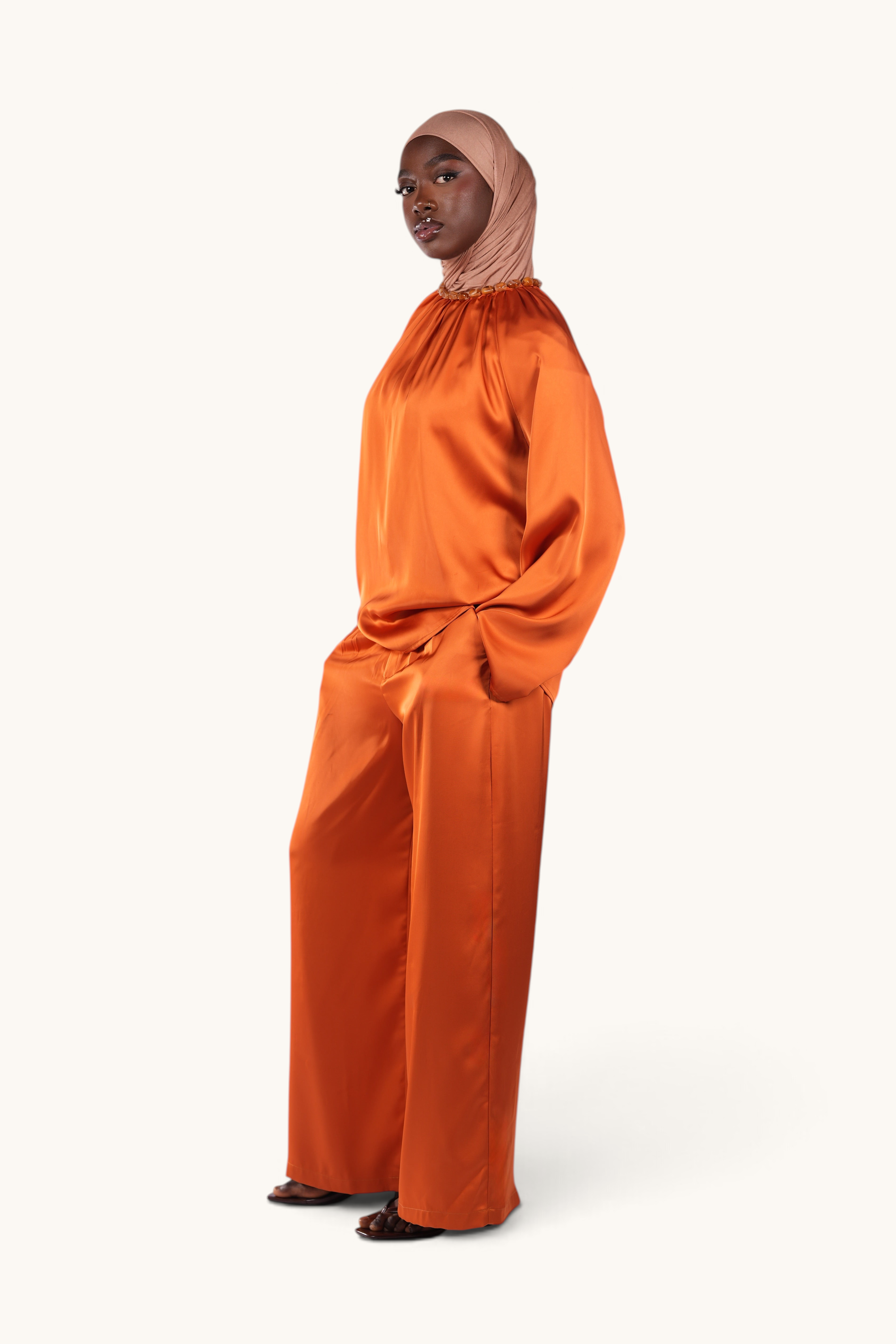 LOSYANA La Marina papaya satin two-piece set featuring wide-leg trousers and a top with an acrylic stone collar.