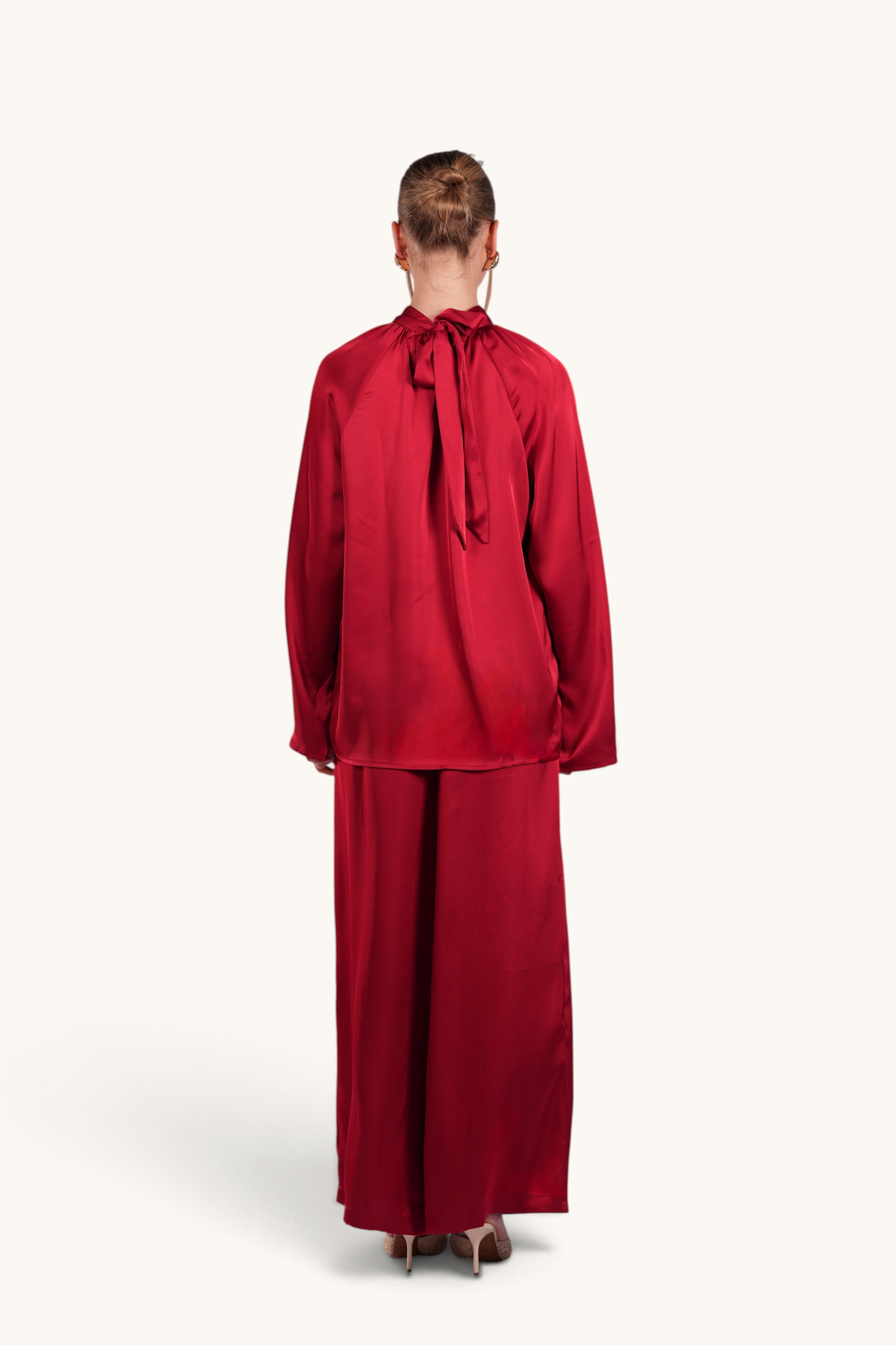 LOSYANA La Palma red satin two-piece set featuring a high-collar top with back bow detail and wide-leg trousers.