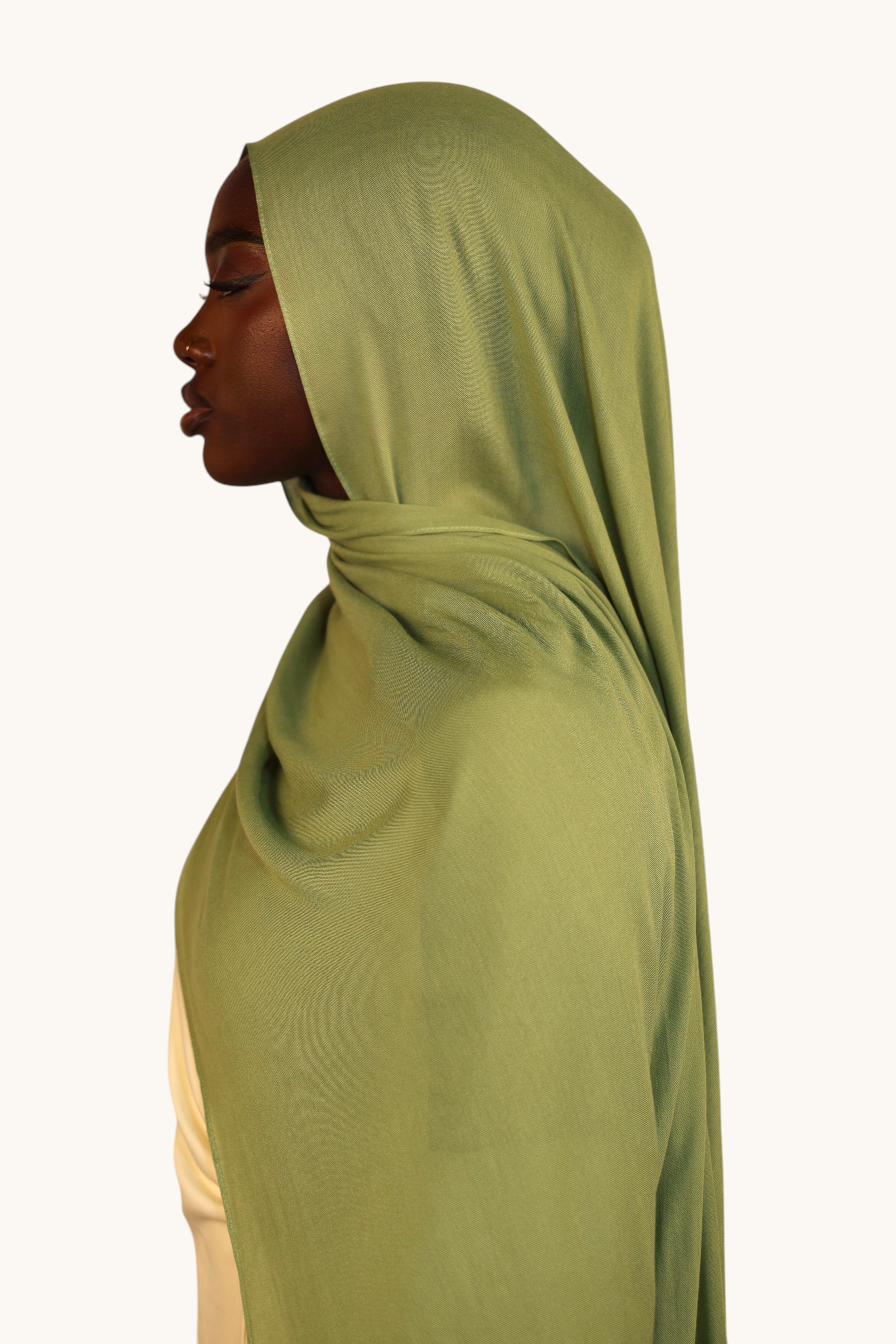 LOSYANA lightweight modal hijab in light olive green worn by a model, showing a soft, elegant, and flowing drape.
